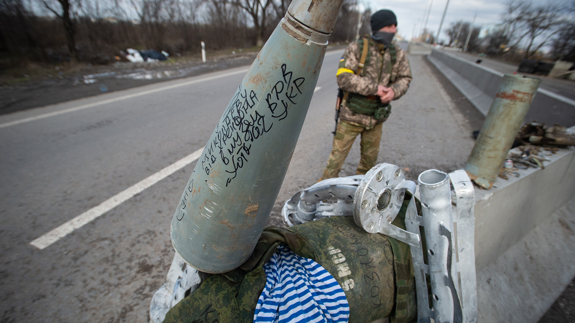 The remains of a cluster bomb rocket and other ordnance are collected as Ukraine Army troops dig in at frontline trench positions east of the strategic port city of Mykolaiv, Ukraine, on March 10, 2022.