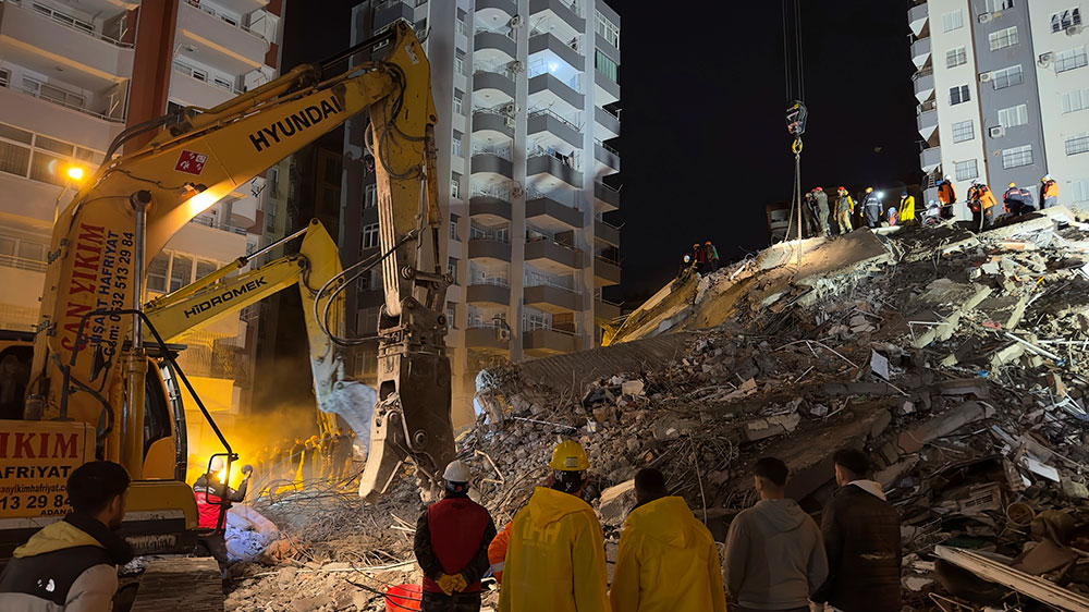Workers use heavy machinery to search through the debris in Adana, on Monday, February 6.