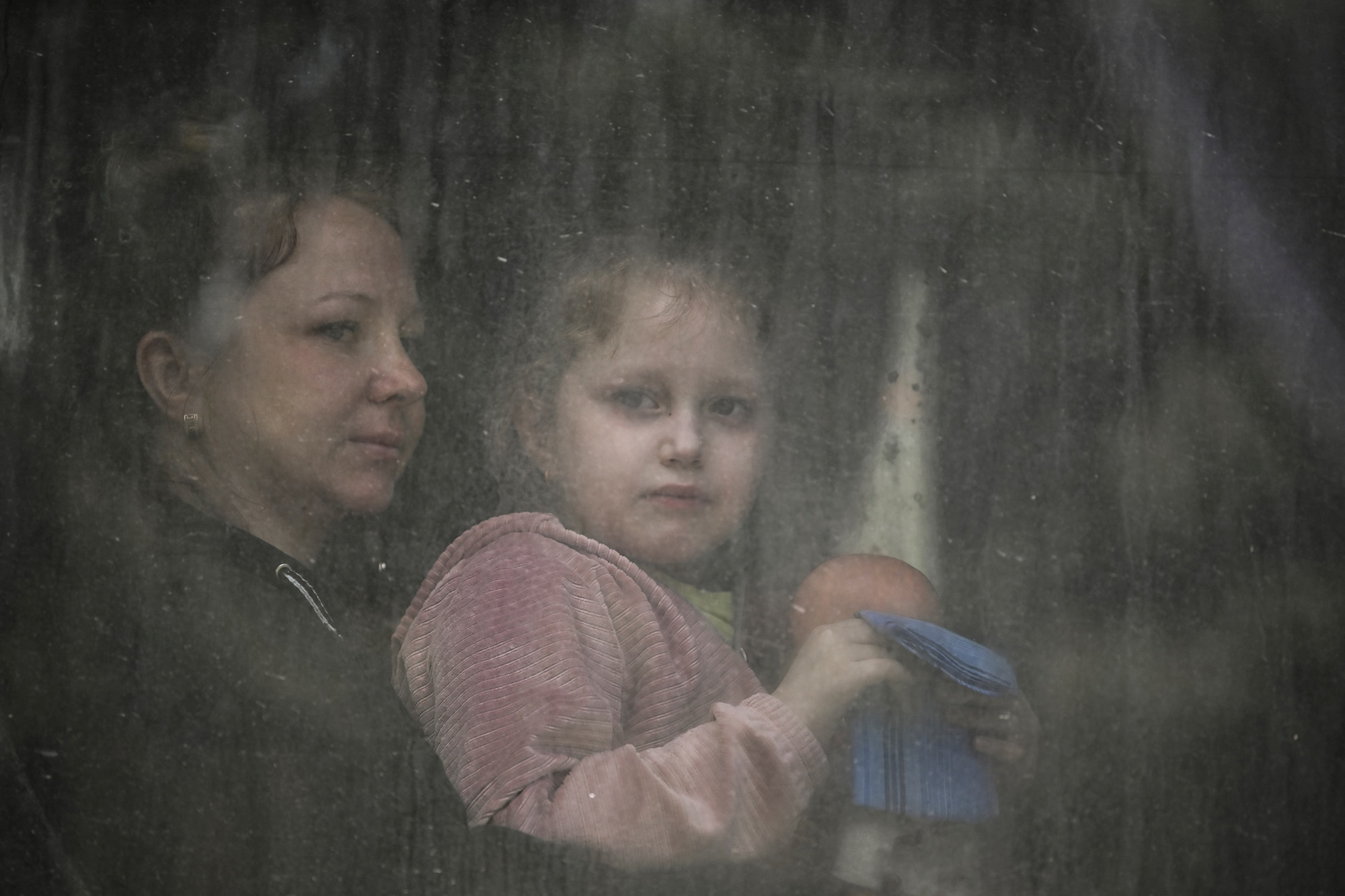 A mother with her daughter sit inside a bus as they evacuate the city of Bakhmut in the Donbas region of Ukraine on May 22.