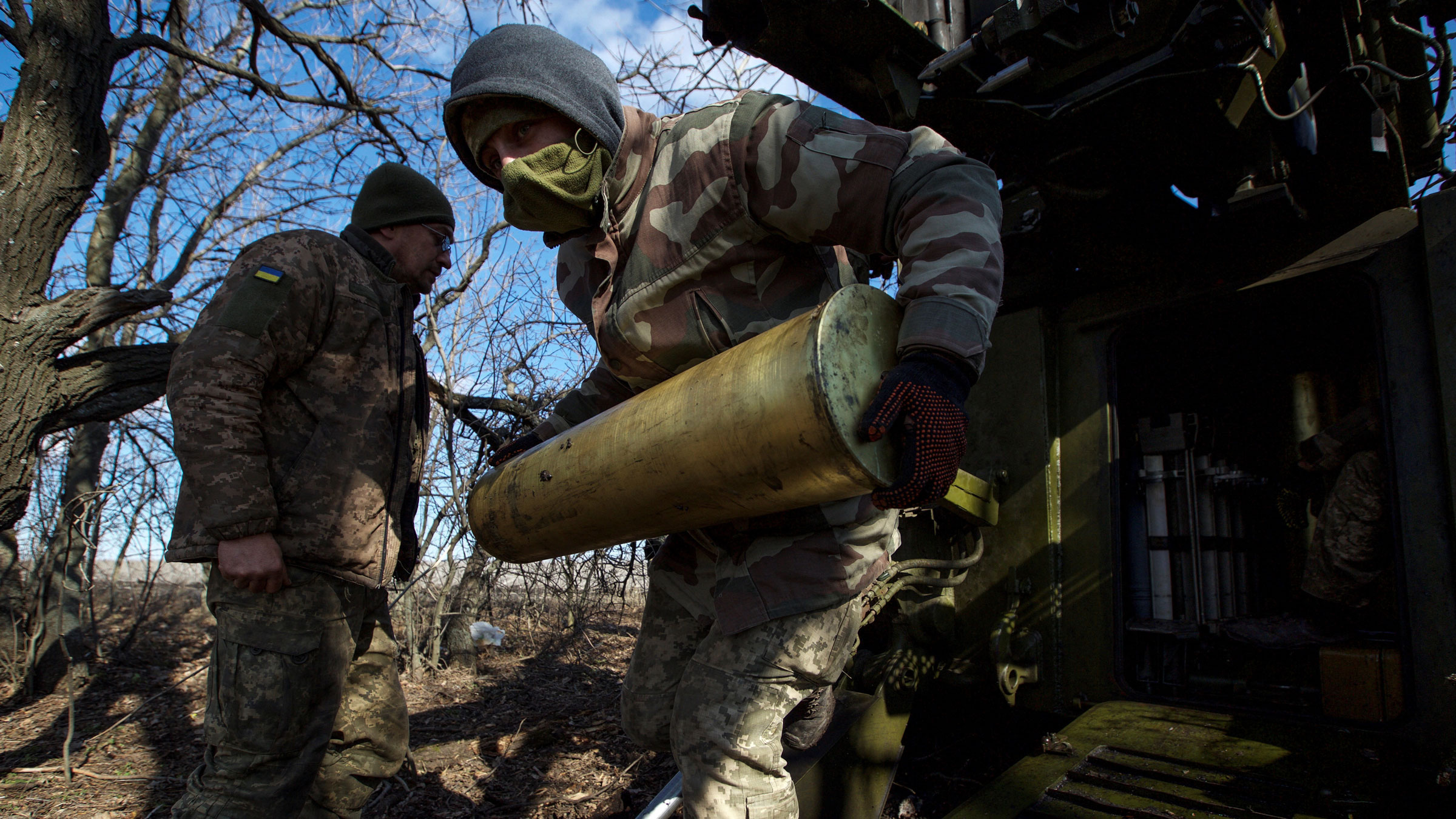 周日，一名乌克兰军人携带一枚自行榴弹炮的炮弹，然后向乌克兰巴赫穆特郊外的俄罗斯军队发射。