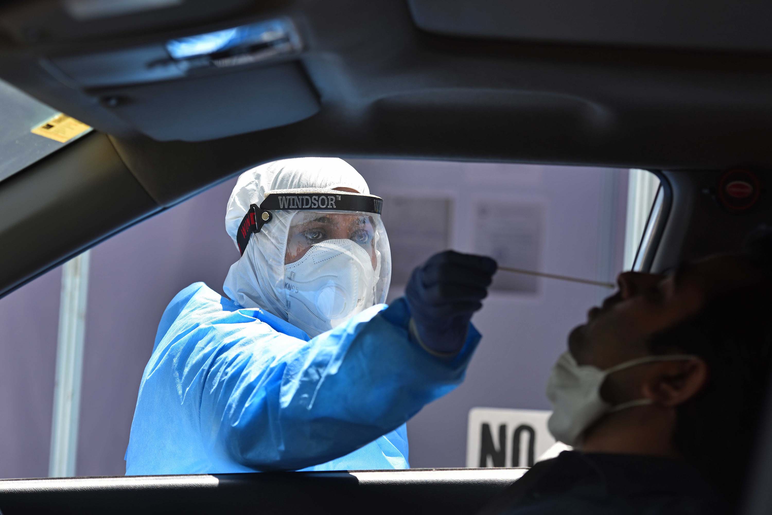 A medic demonstrates taking samples at a drive-through coronavirus testing facility in New Delhi, India, on April 6.