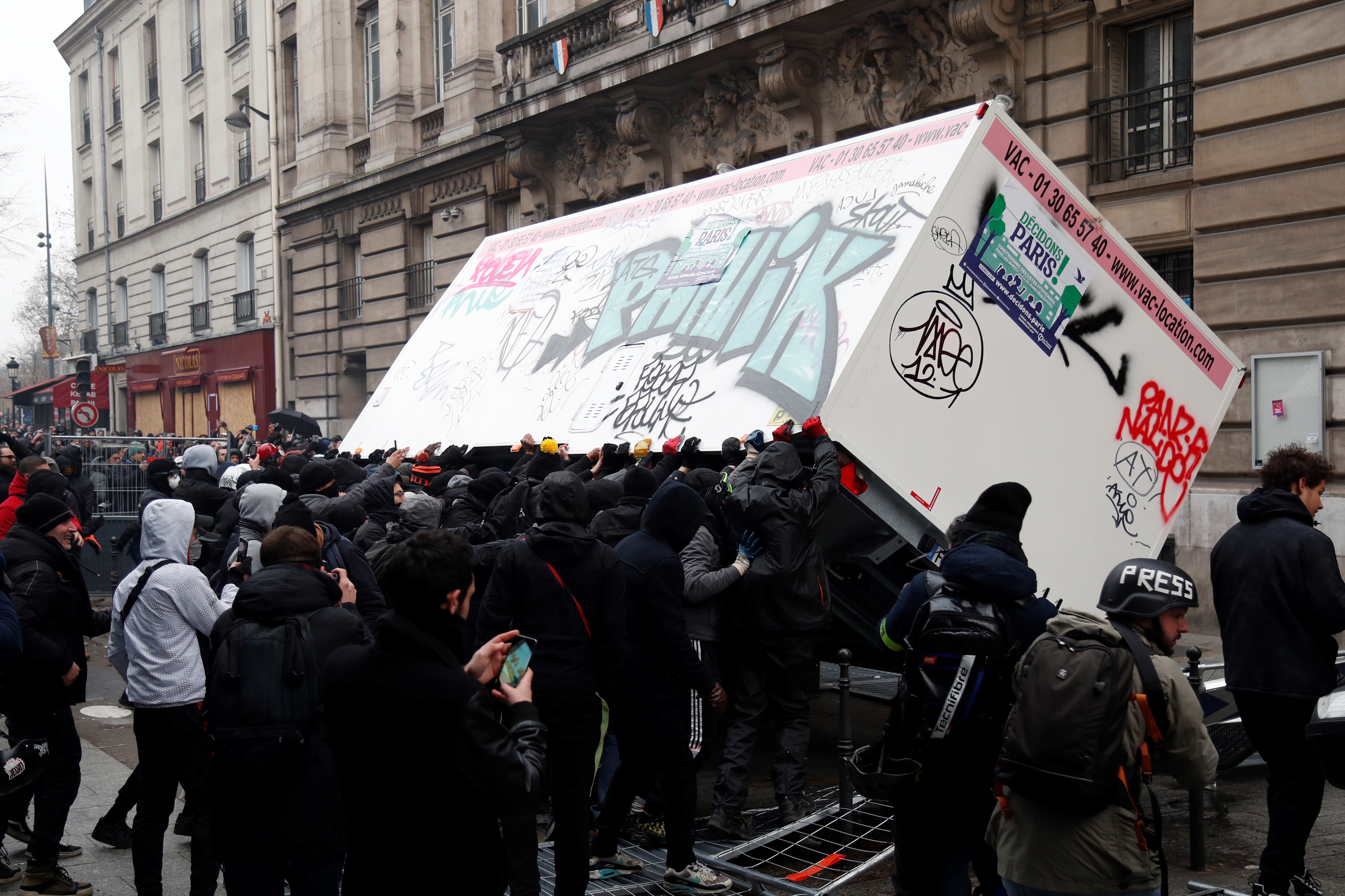 Demonstrators overturn a container in Paris