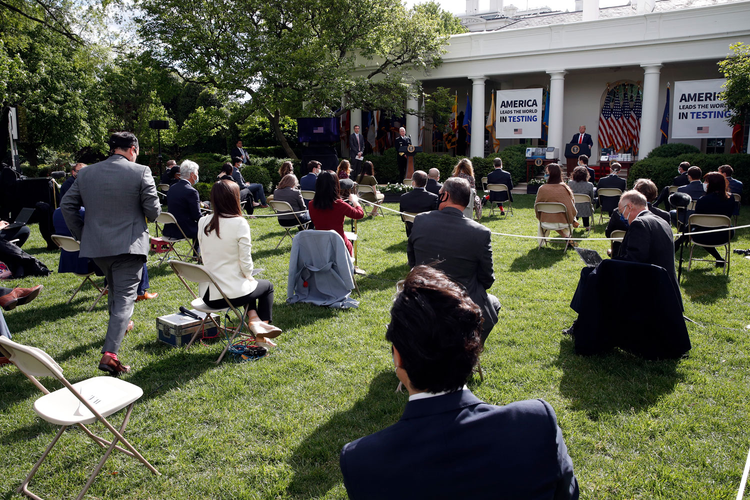 A reporter approaches a microphone to ask as question of President Donald Trump during a briefing about the coronavirus in the Rose Garden of the White House on May 11 in Washington. 