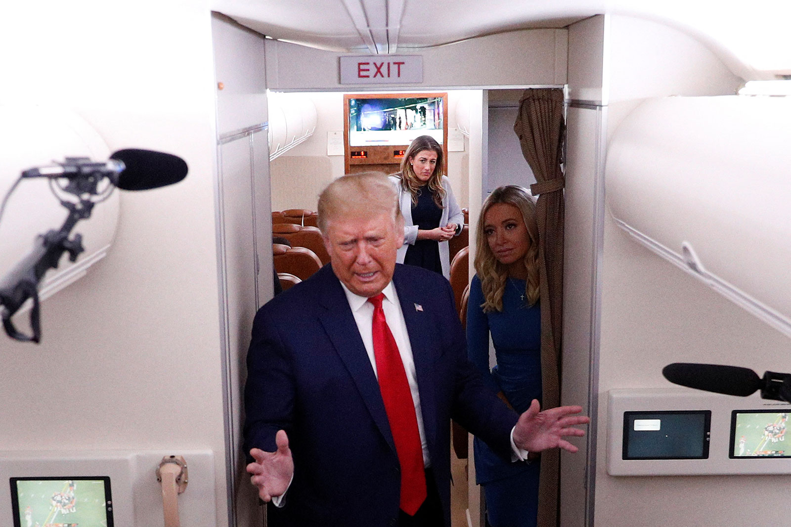 Cassidy Hutchinson, center, and then-White House press secretary Kayleigh McEnany watch then-President Trump speak to journalists aboard Air Force One in September 2020.