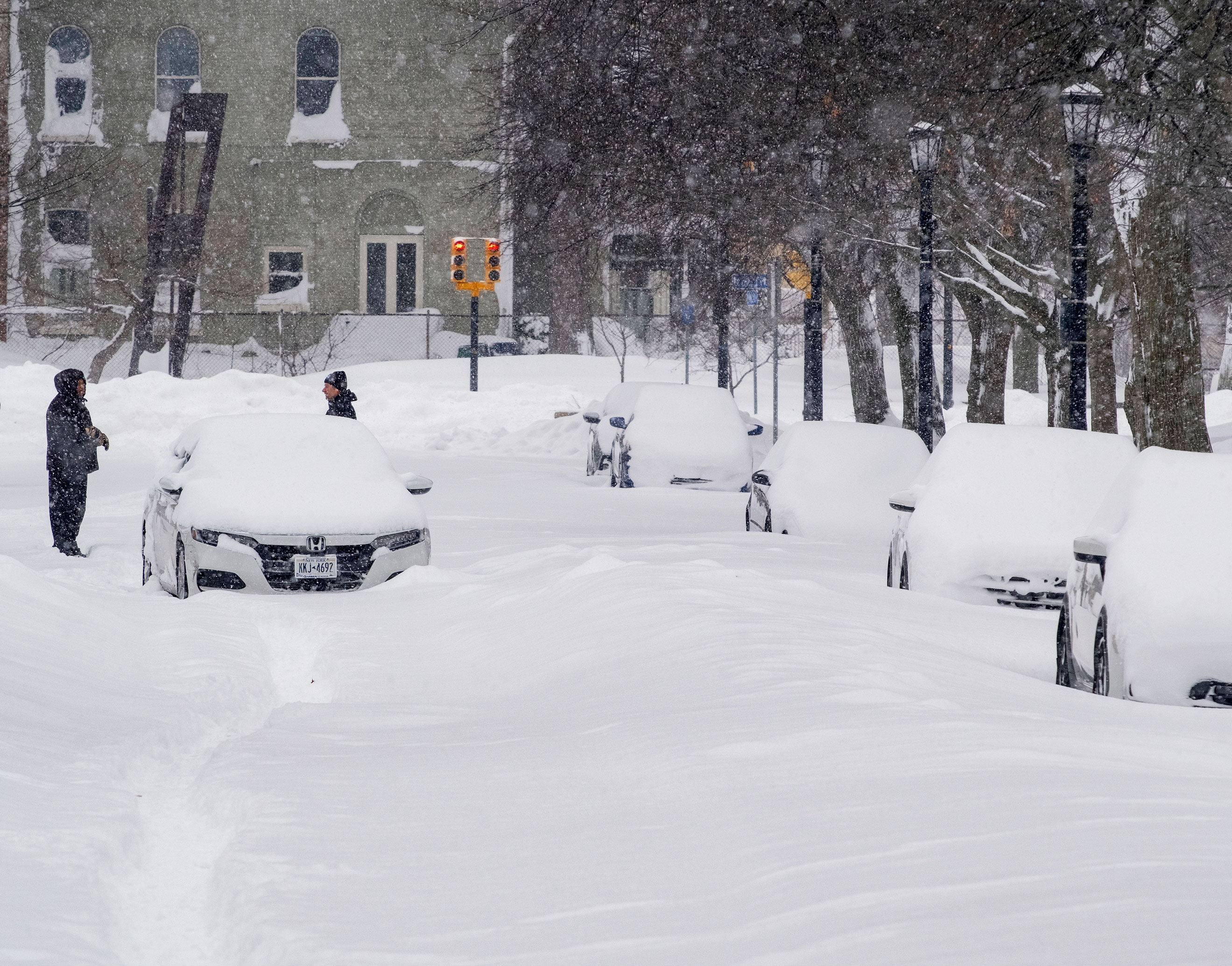 An abandoned car rests on a street in Buffalo on Monday after a massive snow storm blanketed the city.