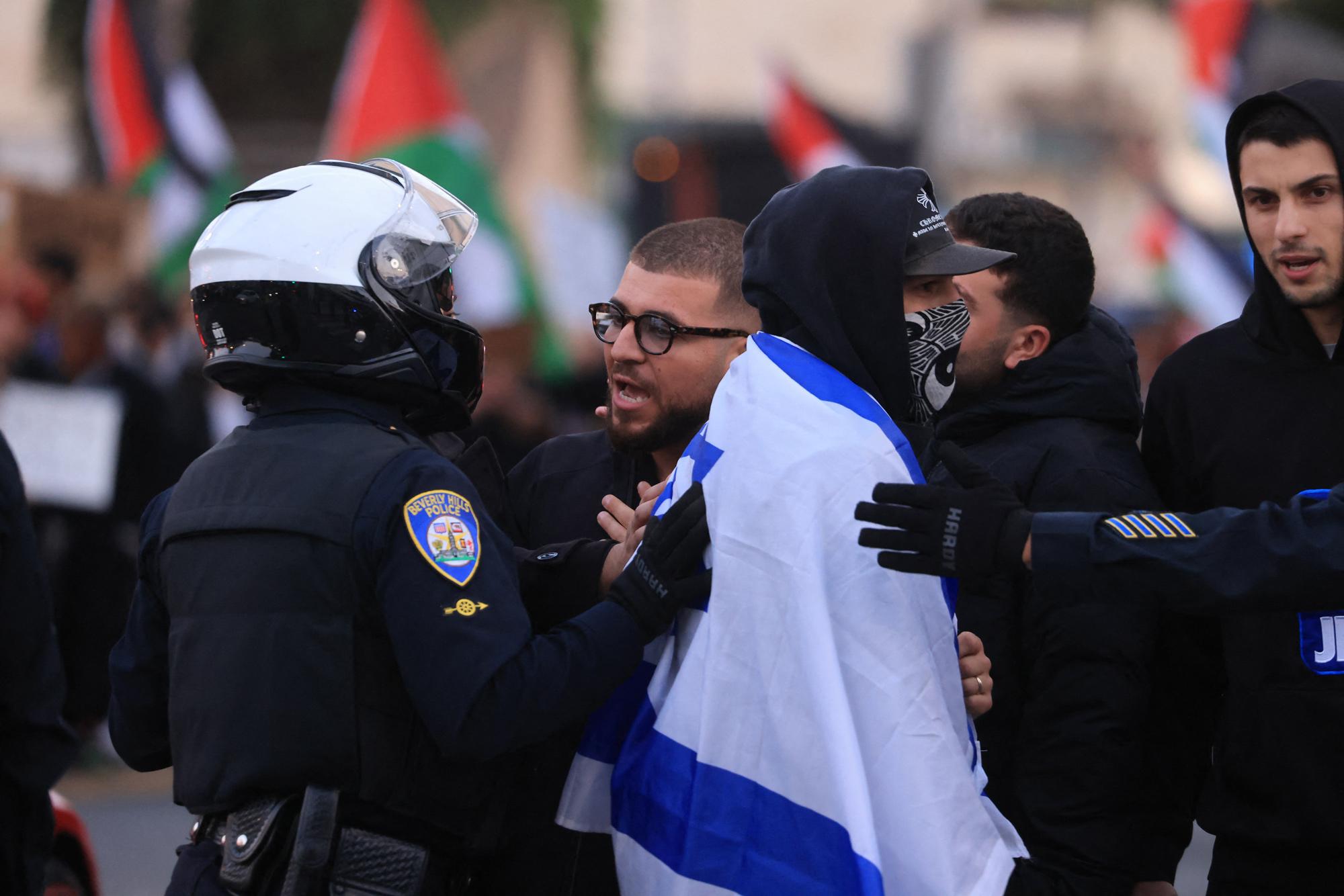 Police officers control an interaction between Israeli counter protesters as pro-Palestinian protesters rally during the "Black & Palestinian Solidarity for a Ceasefire this Xmas" by the Beverly Center shopping center in Los Angeles on December 23.
