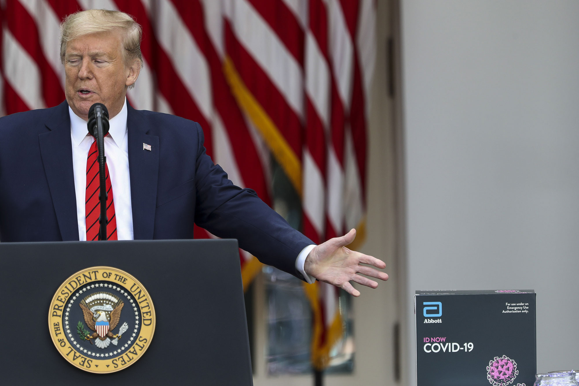 An Abbott Laboratories ID Now Covid-19 test kit stands next to U.S. President Donald Trump speaking during a press briefing in the Rose Garden of the White House in Washington, on May 11.