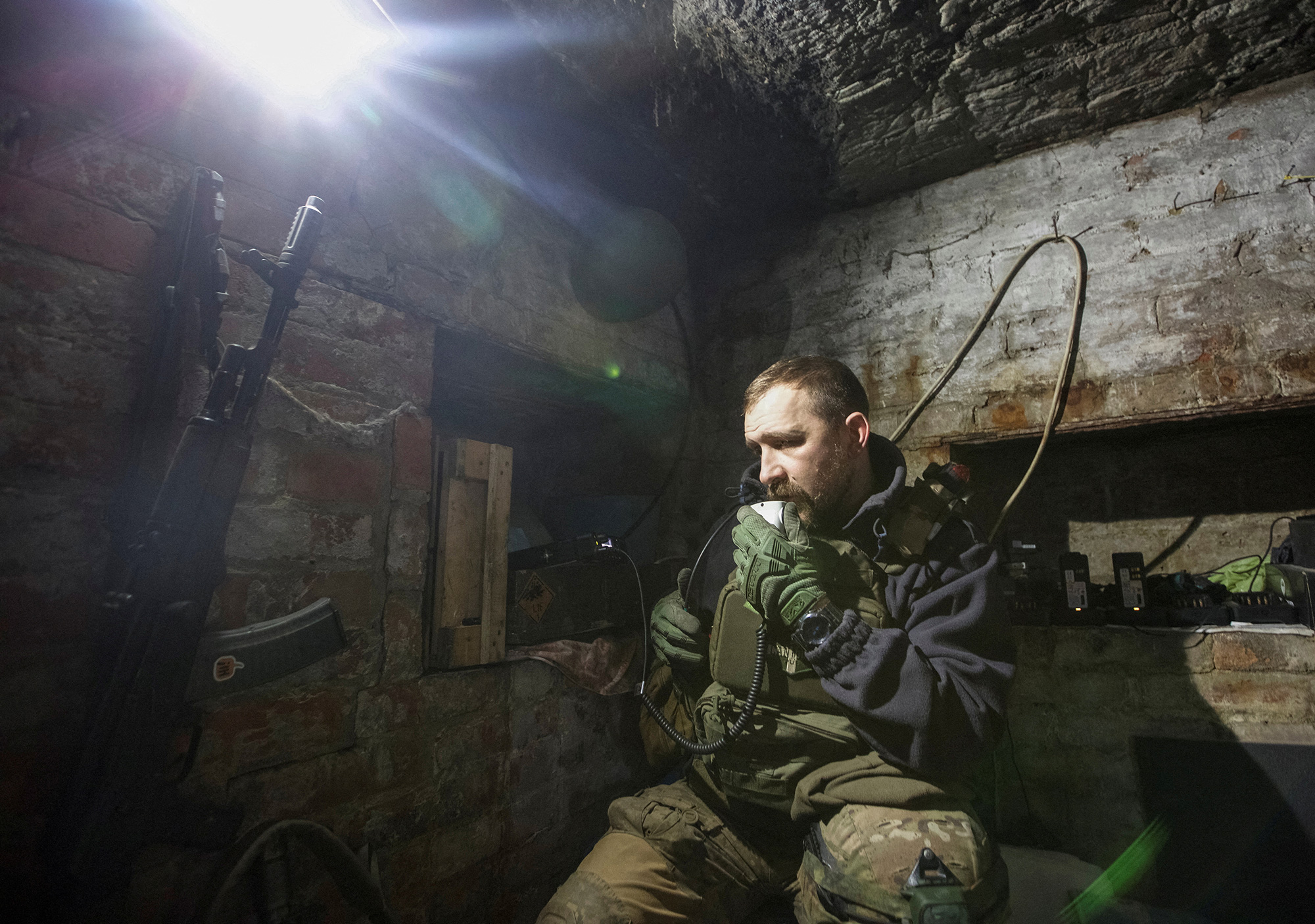 A Ukrainian service member uses a radio in a shelter near their position at a frontline in Bakhmut, Ukraine, on January 1. 