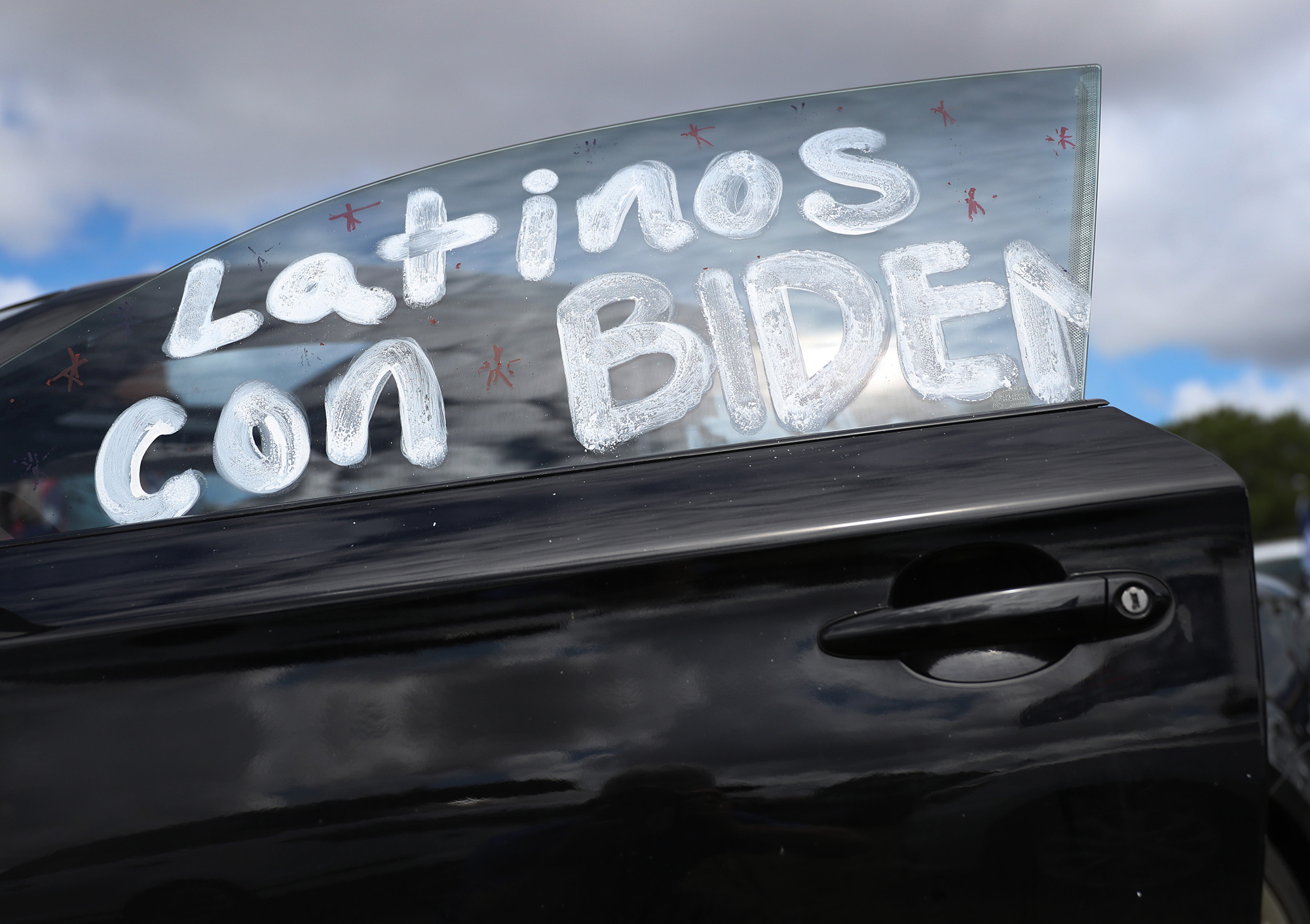 Writing on a car window reads, ' Latinos con Biden,' as people show their support for Democratic presidential nominee Joe Biden during a Worker Caravan for Biden event on October 18 in Doral, Florida. 