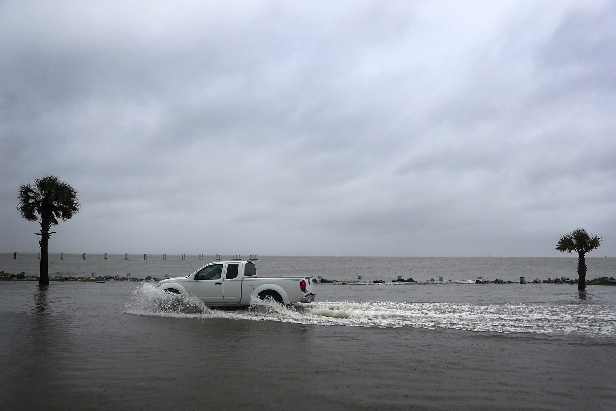 A driver navigates along a flooded road as the outer bands of Hurricane Sally come ashore on September 15 in Bayou La Batre, Alabama. 