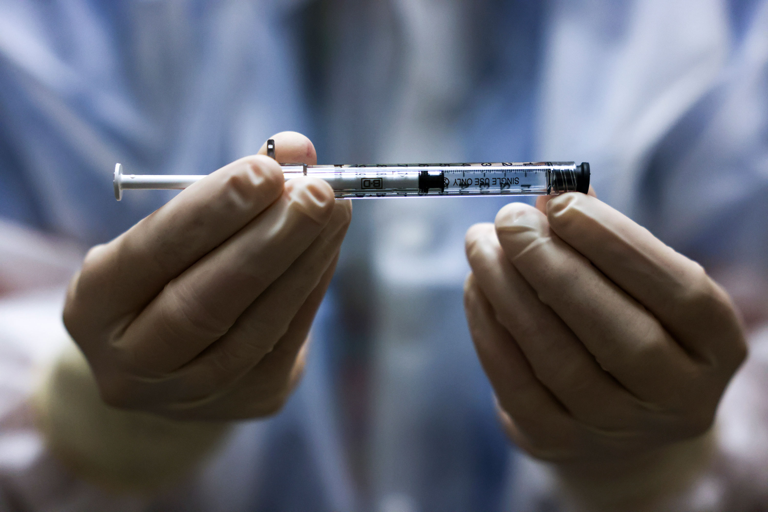 An investigational pharmacy technician holds a dose of the Johnson & Johnson Covid-19 vaccine before it is administered in a clinical trial in Aurora, Colorado, on December 15, 2020.