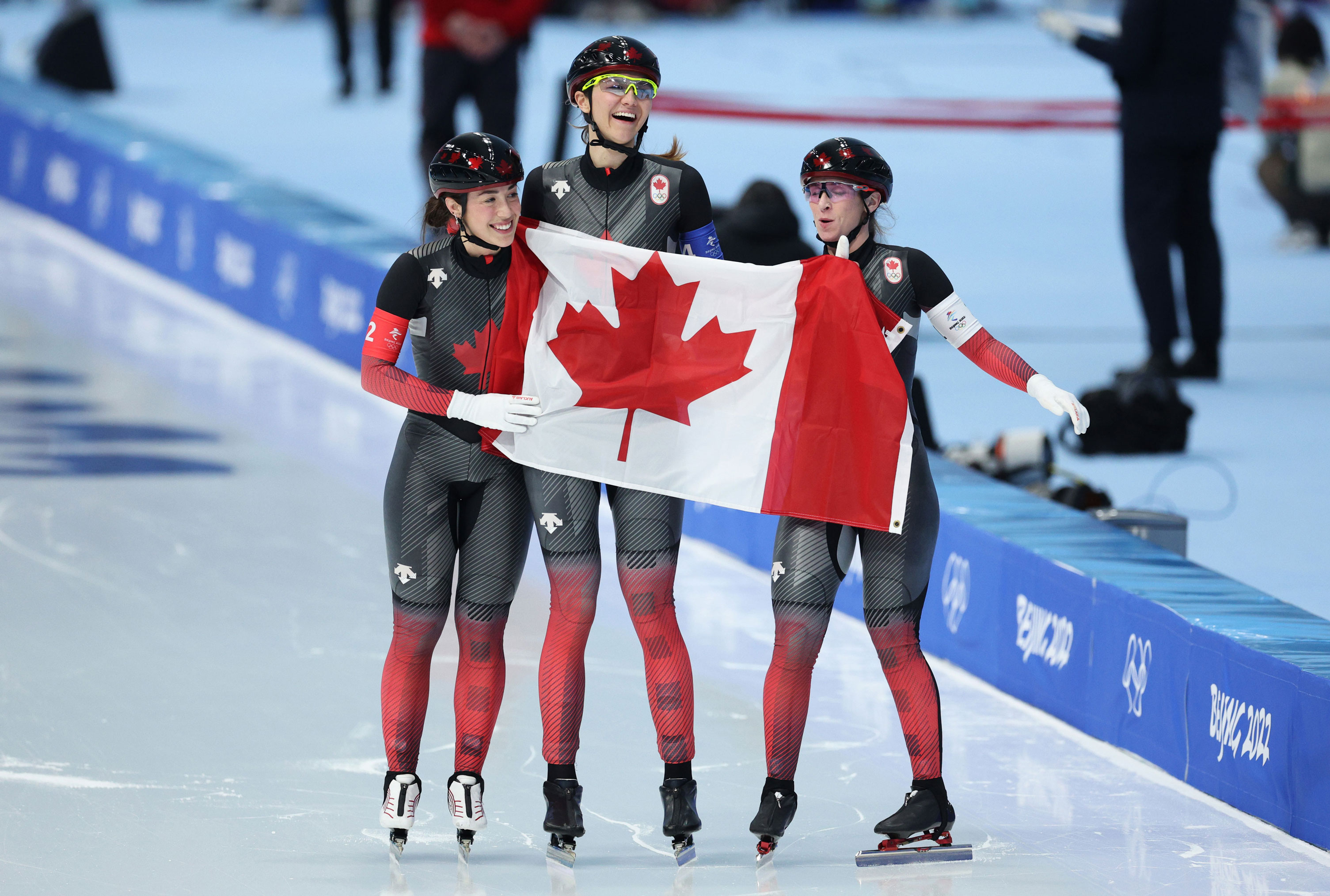 Team Canada celebrate after winning the gold at the women's team pursuit on February 15.