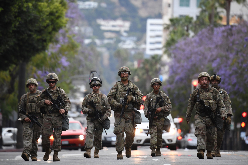 Armed National Guard soldiers patrol on Hollywood Boulevard on June 1 as peaceful protests and looting continue in Los Angeles County. 