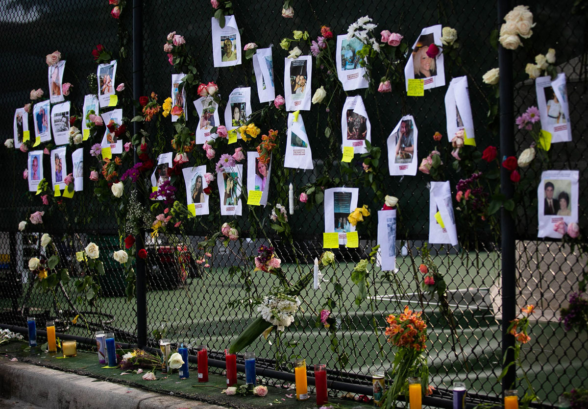 Photos of missing residents are posted at a makeshift memorial on June 26.