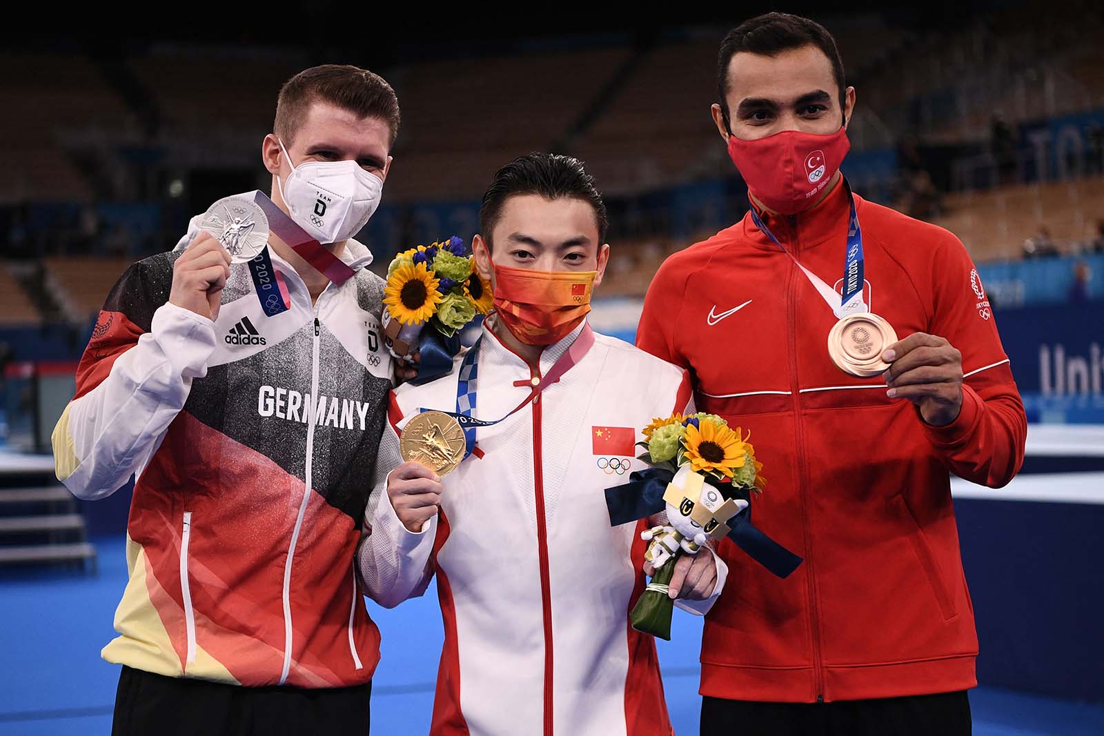 From left: Silver medalist Lukas Dauser of Germany, gold medalist Zou Jingyuan of China, and bronze medalist Ferhat Arican of Turkey pose during the medal ceremony of the artistic gymnastics men's horizontal bar on August 3.
