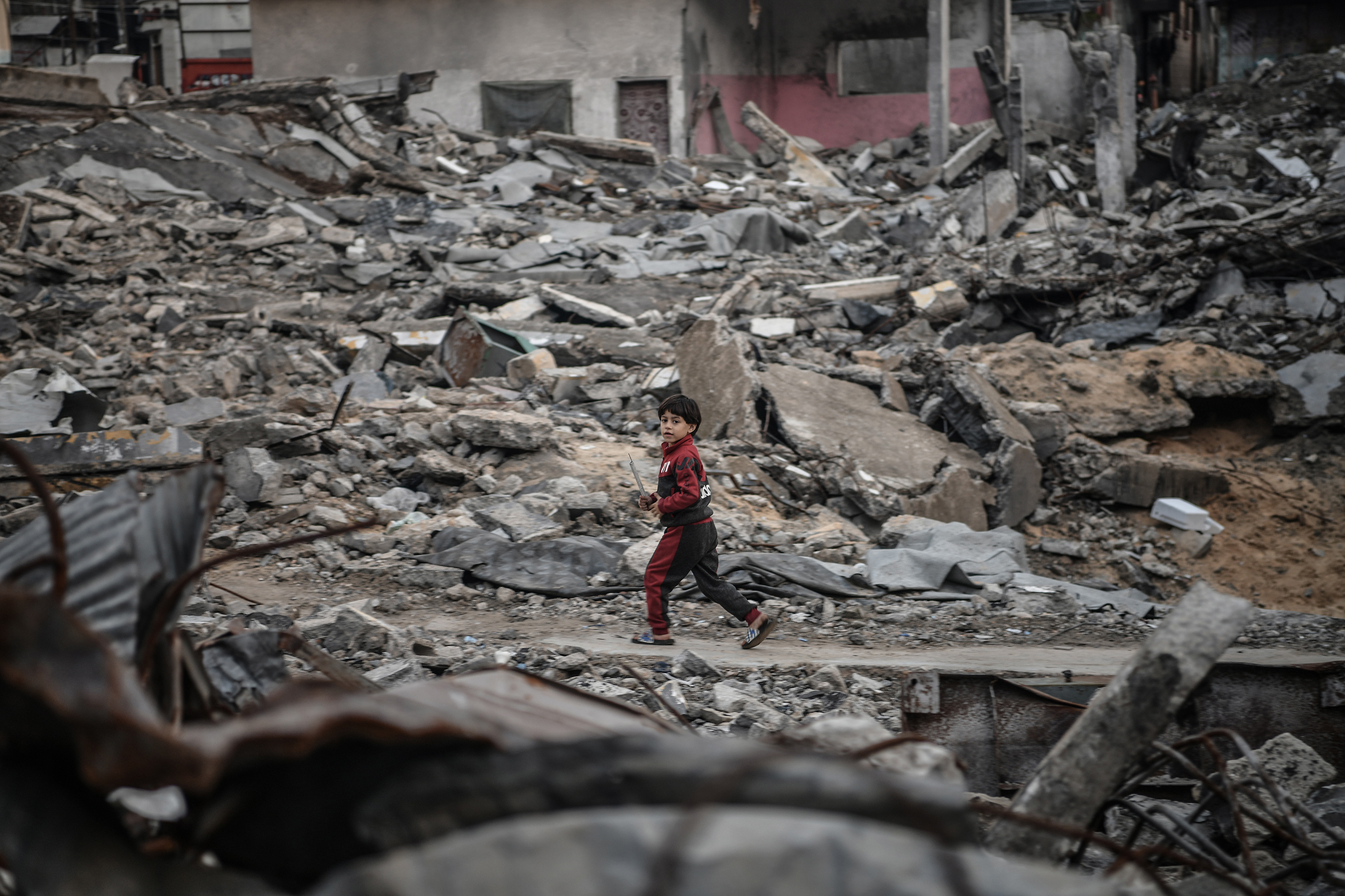 A Palestinian child is seen in the rubble of a building destroyed by an Israeli attack in Rafah, Gaza on January 3.
