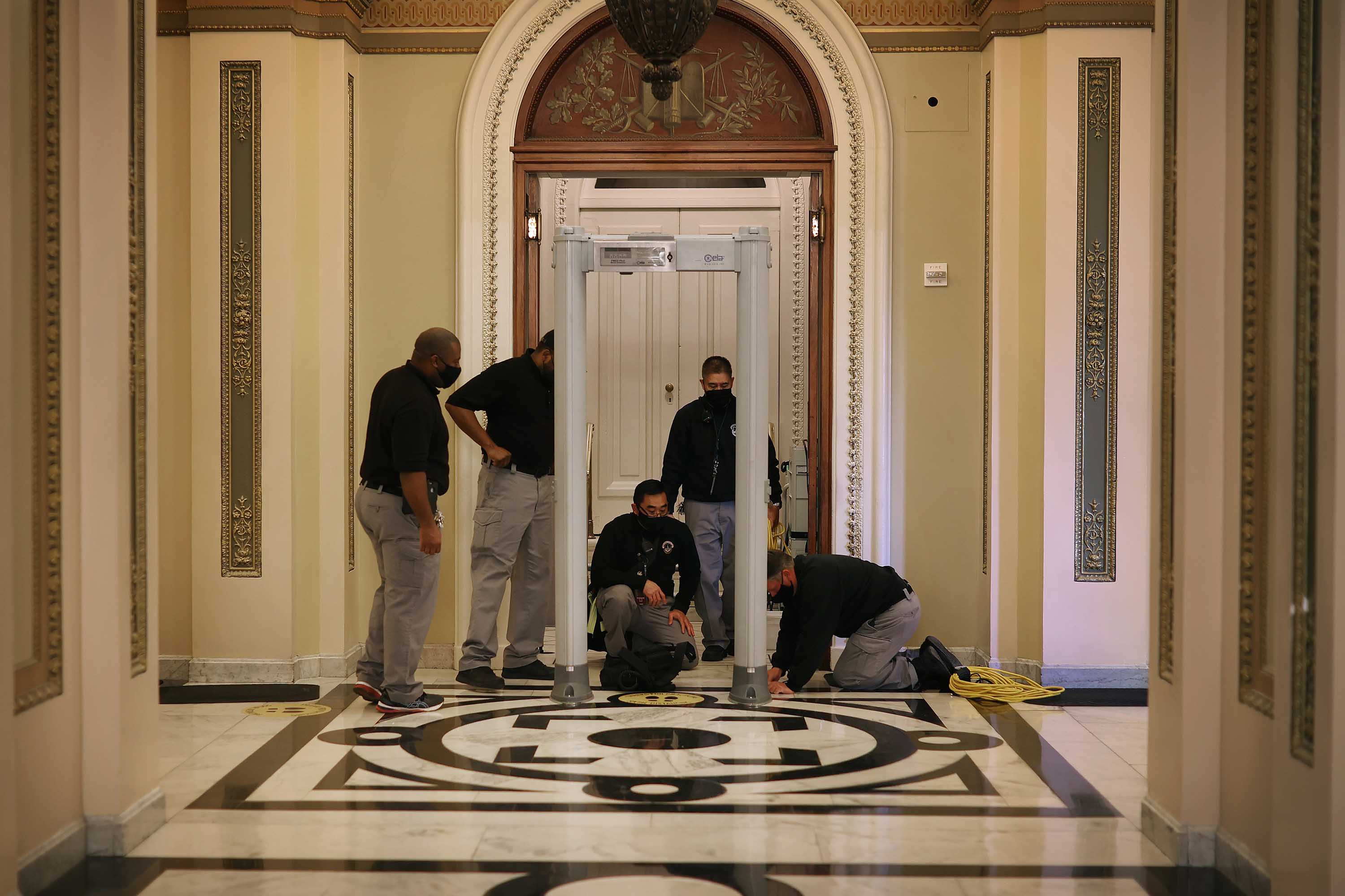 U.S. Capitol Police install a metal detector outside the House of Representatives Chamber at the US Capitol in Washington, DC, on January 12.