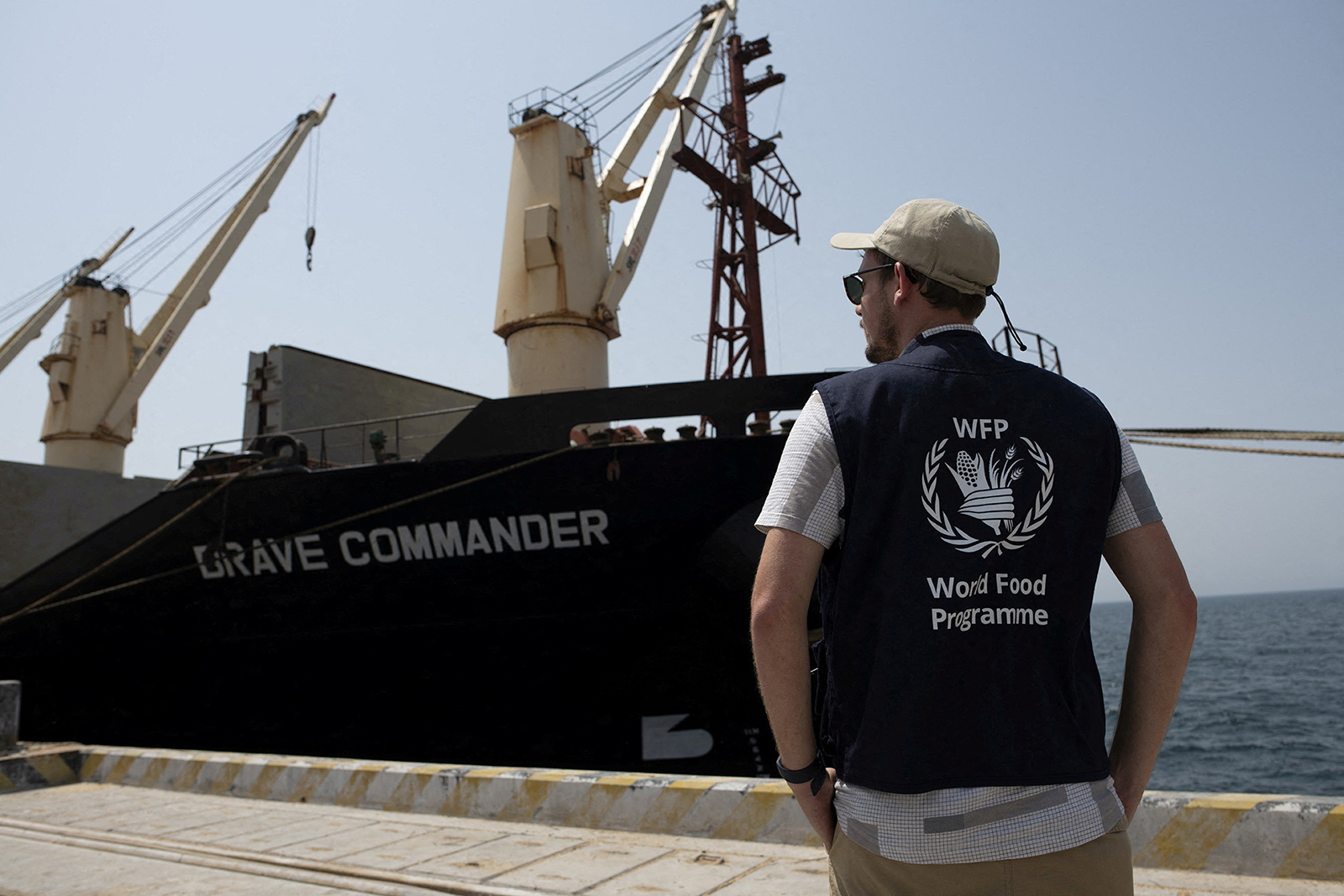 A World Food Programme staff stands near the MV Brave Commander carrying wheat grain from Yuzhny Port in Ukraine to the Horn of Africa docks in Djibouti on August 30.