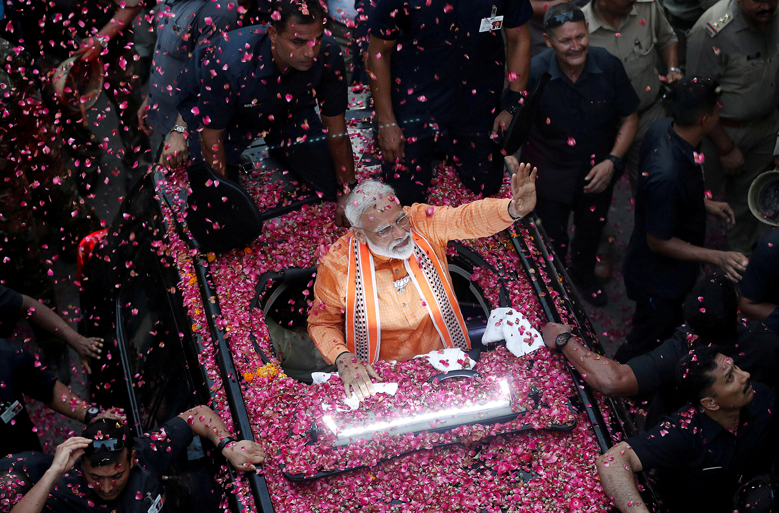India's Prime Minister Narendra Modi waves towards his supporters during a roadshow in Varanasi, on April 25, 2019. 