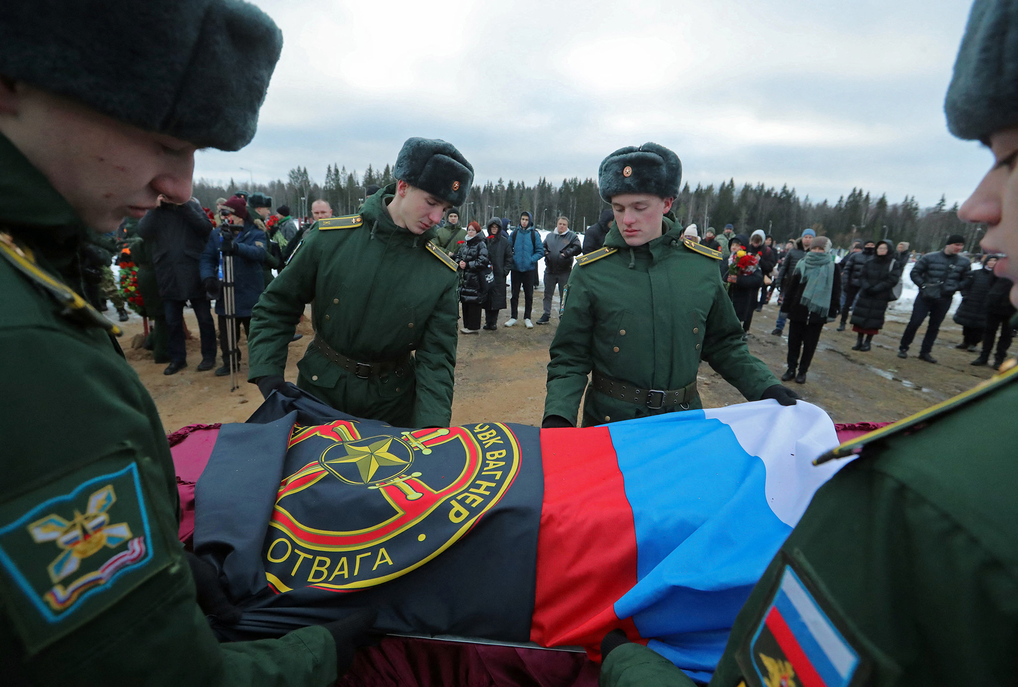 Military academy cadets cover the coffin with flags during the funeral of a Wagner Group mercenary killed in Ukraine at a cemetery in St. Petersburg, Russia, on December 24, 2022. 