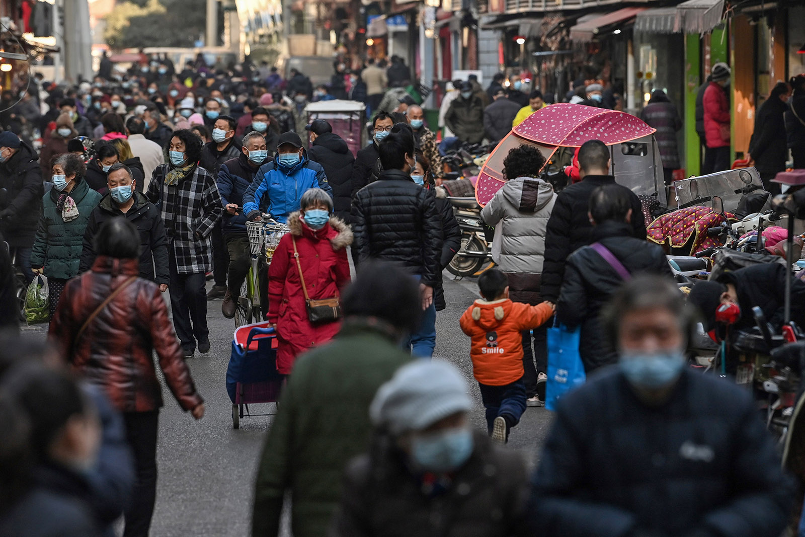People walk along a street near a market in Wuhan, China, on January 19.