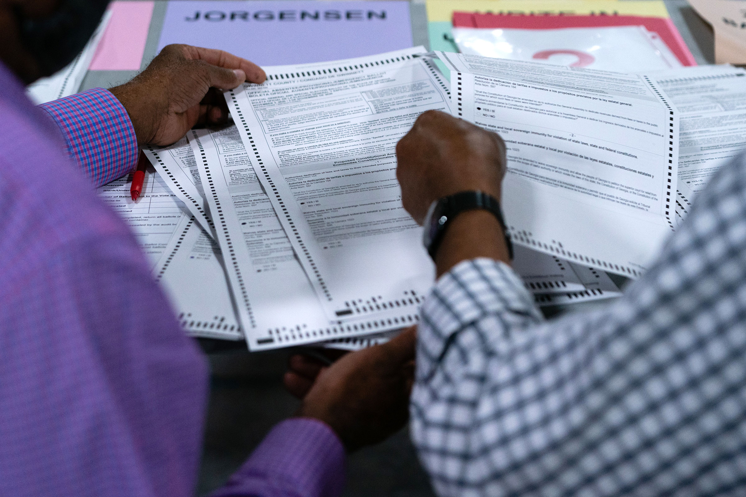 People hand count ballots at the Gwinnett County Voter Registration office on November 13 in Lawrenceville, Georgia