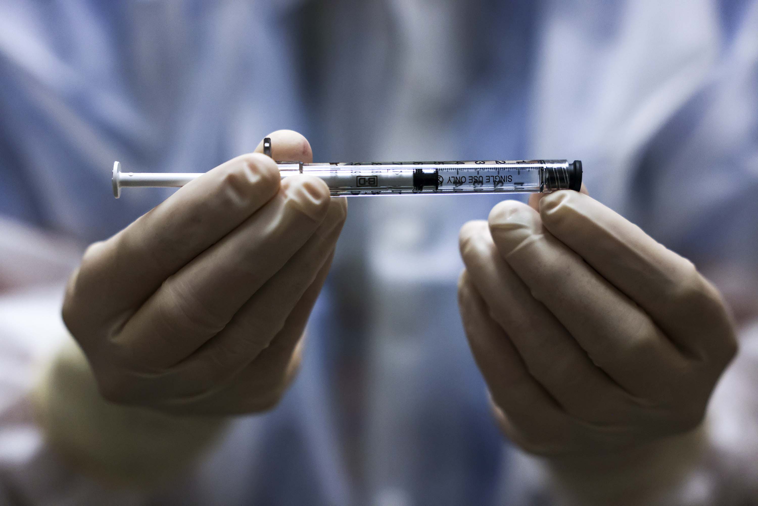 Rocky Mountain Regional VA Medical Center investigational pharmacy technician Sara Berech holds a dose of the Johnson & Johnson COVID-19 vaccine before it is administered in a clinical trial on December 15, 2020, in Aurora, Colorado. 