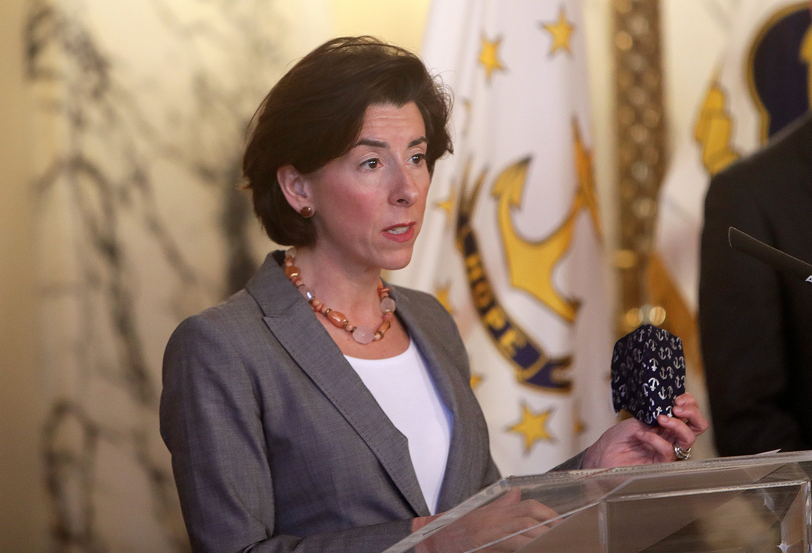 Rhode Island Gov. Gina Raimondo, holding her mask in her left hand, speaks during a press conference in Providence, Rhode Island on April 14.