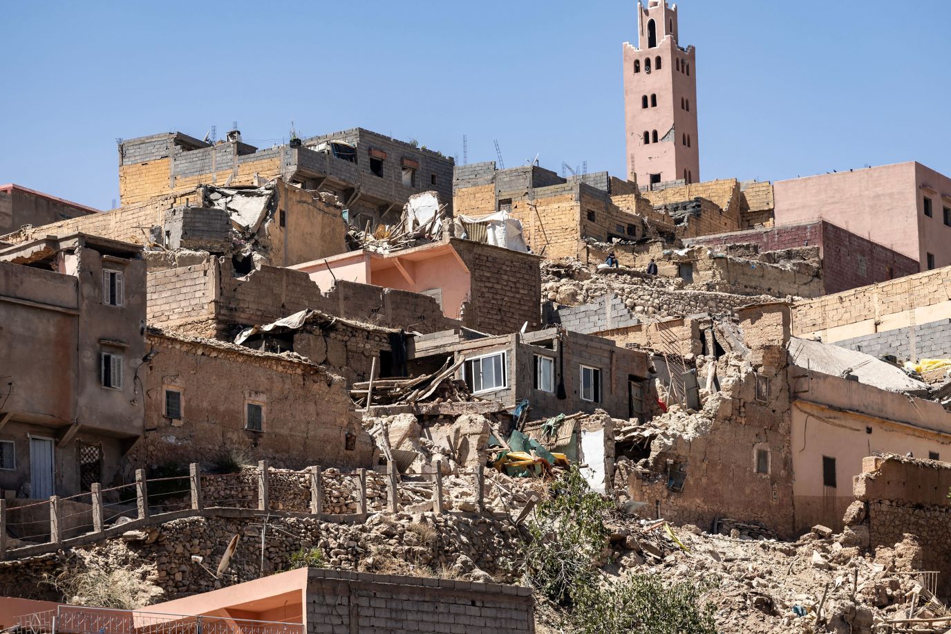 The minaret of a mosque stands behind damaged or destroyed houses following an earthquake in Moulay Brahim, Morocco, on September 9.