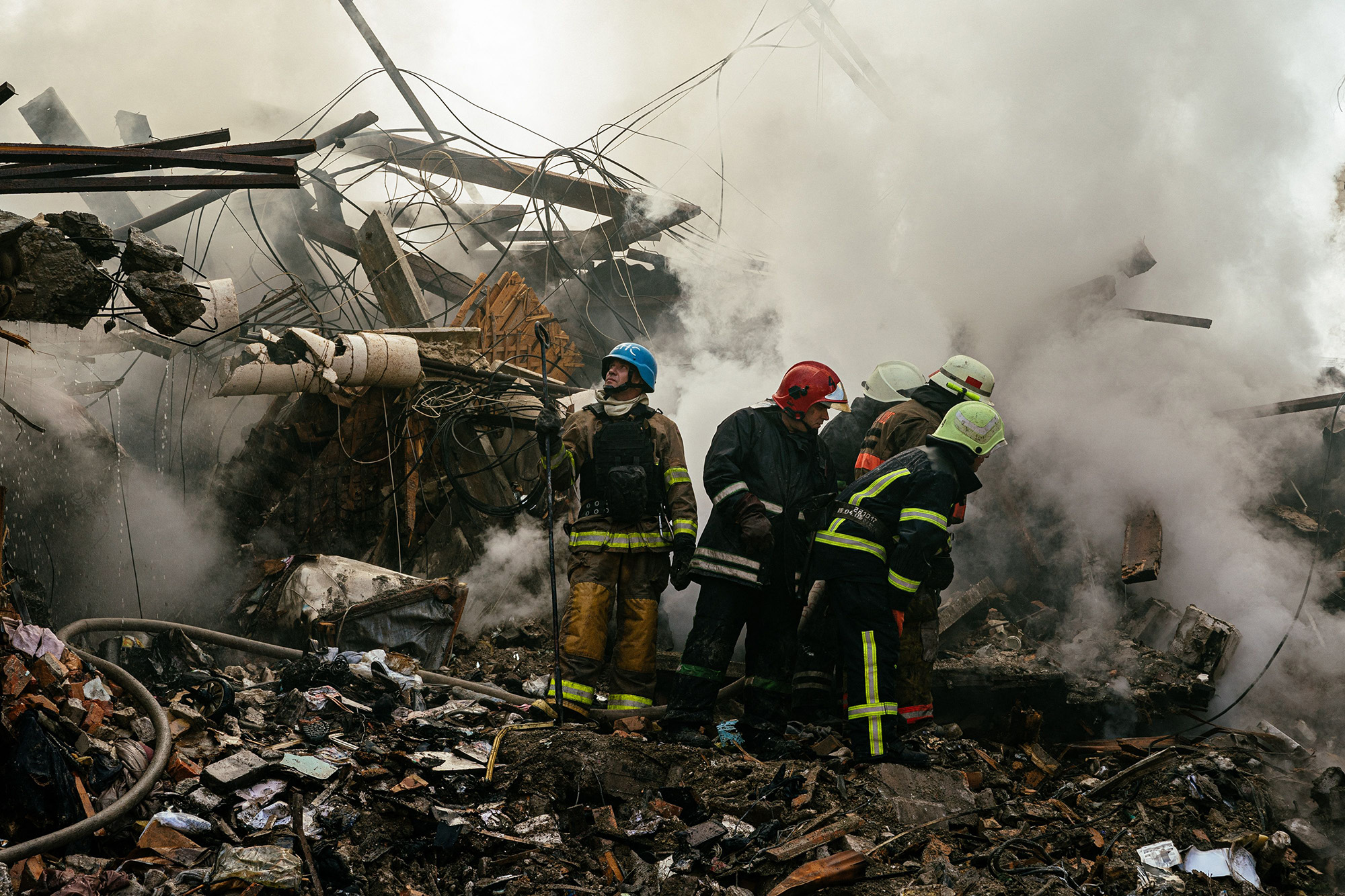 Ukrainian firefighters stand on rubble after a strike in Zaporizhzhia on October 6. 