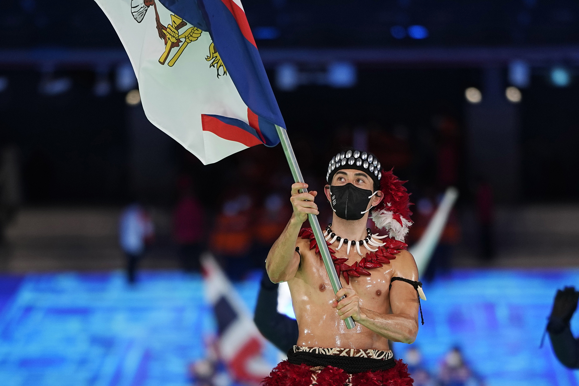 Nathan Crumpton, of American Samoa, carries his national flag into the stadium during the opening ceremony of the 2022 Winter Olympics, February 4 in Beijing. 
