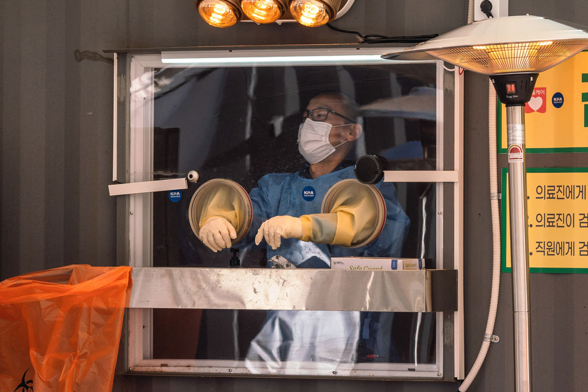 A medical staff wearing a personal protective equipment gear waits for residents at a temporary COVID-19 testing site in Seoul, South Korea on December 20.