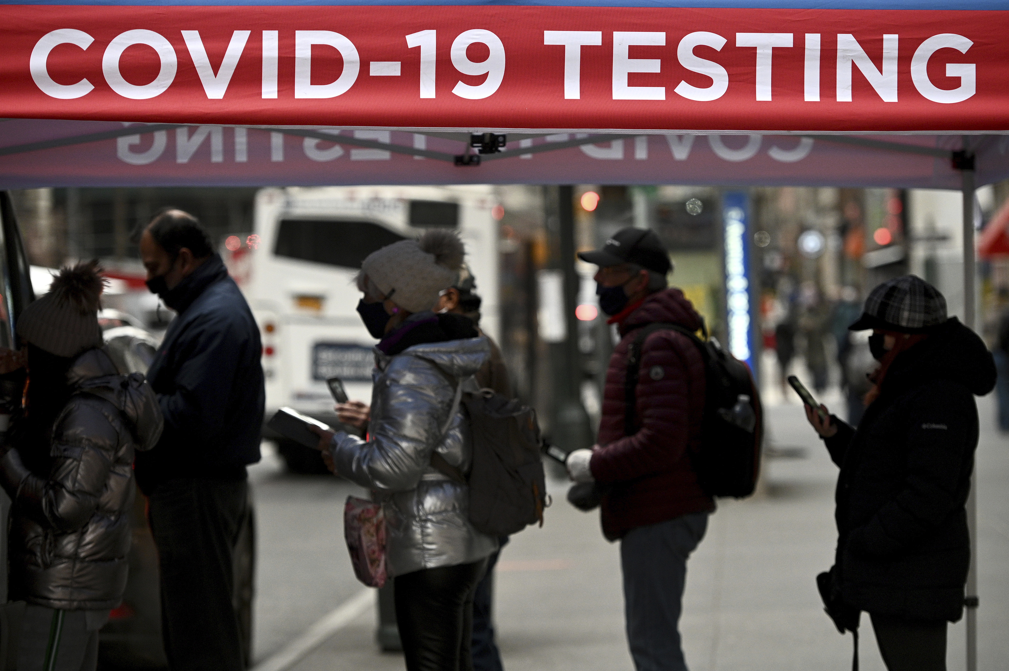 People wait in line to receive a COVID-19 test from a mobile test site set up on near the Empire State Building in New York on January 3, 2022. 