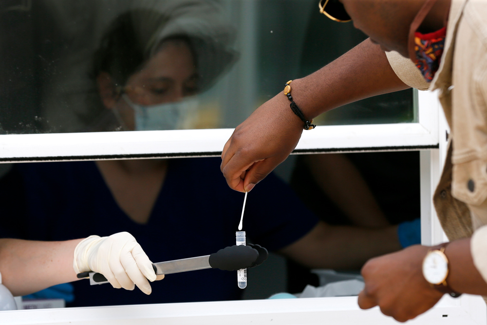 Parkland Hospital employees collect a self-administered test sample from a man at a Covid-19 testing site in Dallas on Thursday.