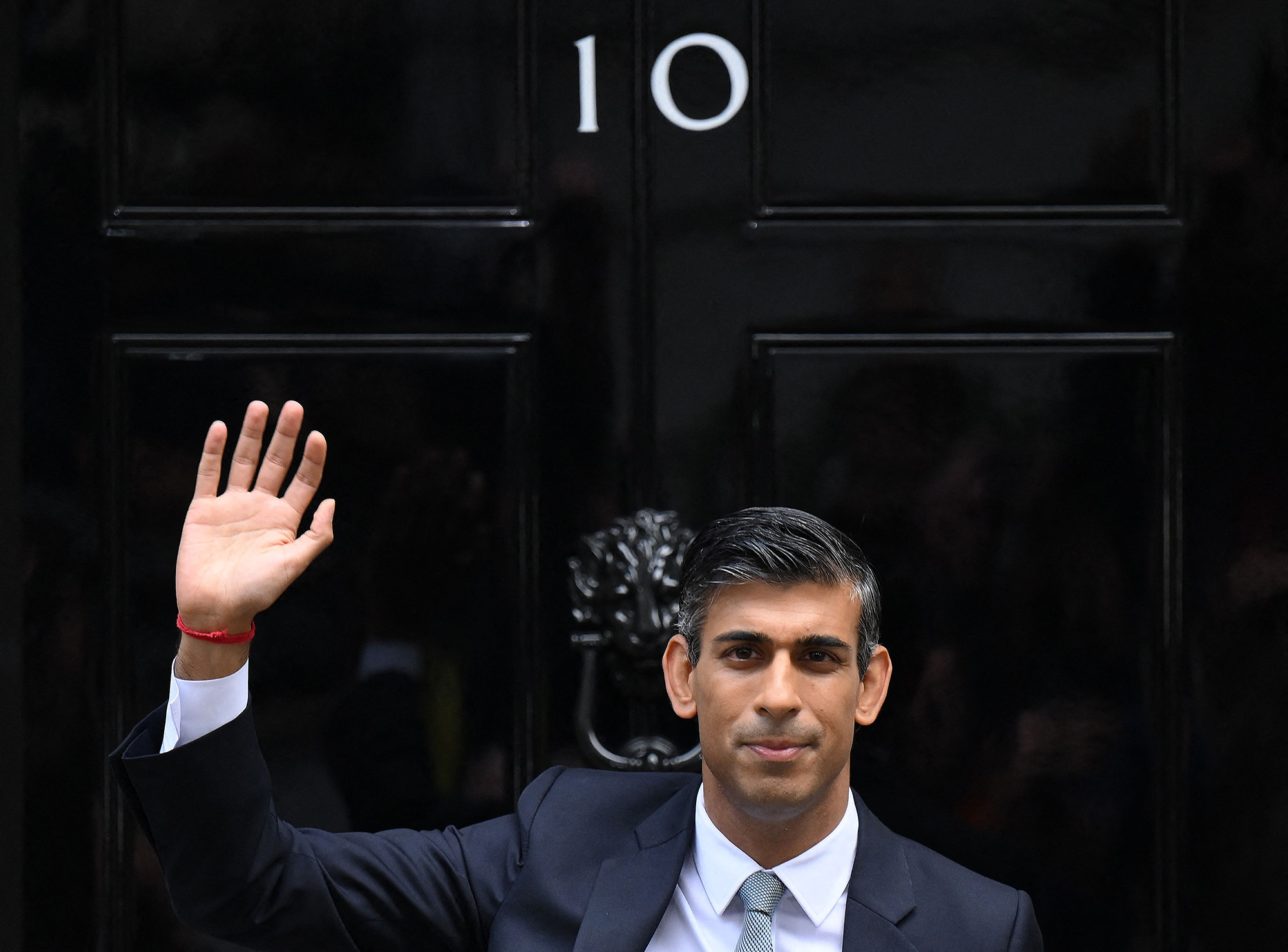 Britain's newly appointed Prime Minister Rishi Sunak waves outside 10 Downing Street in London Tuesday.