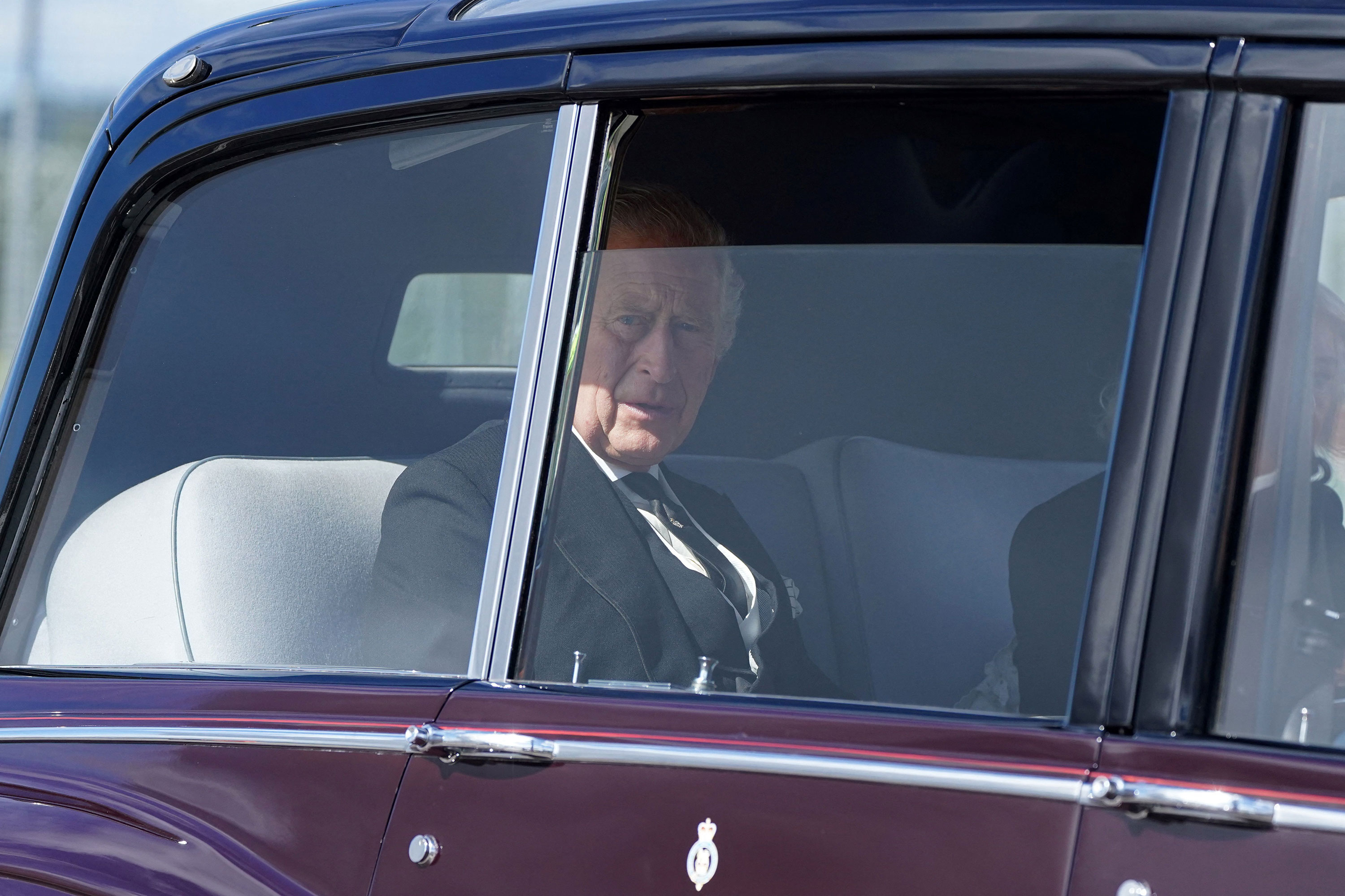 King Charles III and Camilla, Queen Consort are driven away from Edinburgh airport on Monday.