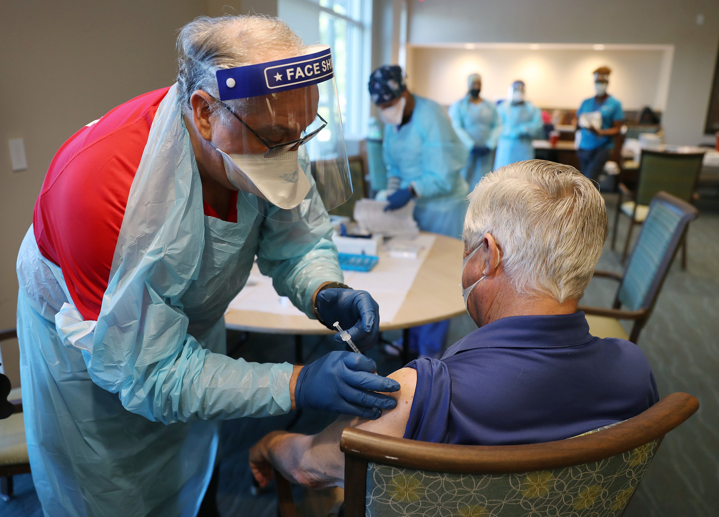 A healthcare worker administers a Pfizer-BioNtech Covid-19 vaccine at a retirement community in Pompano Beach, Florida, on January 6. 