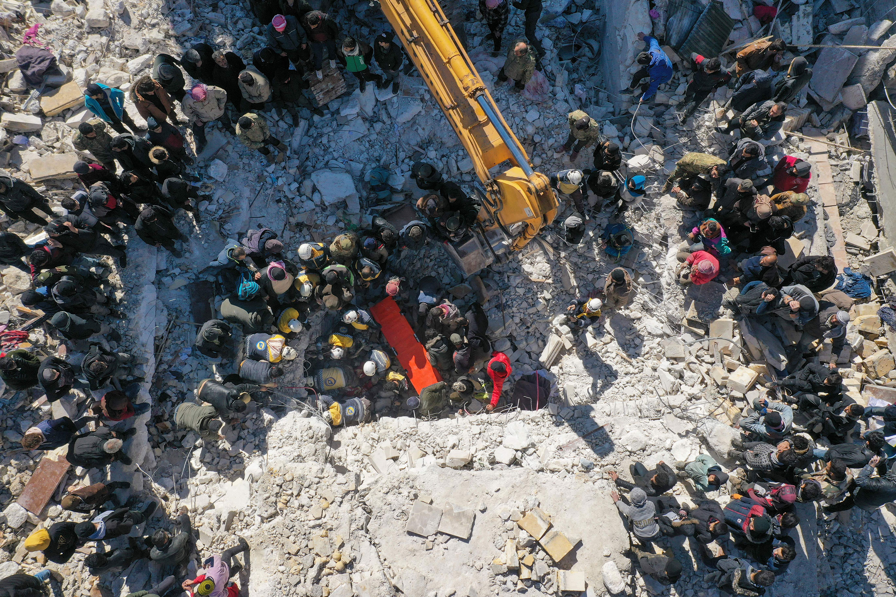 Rescuers search through rubble in Salqin, Syria, on Tuesday.