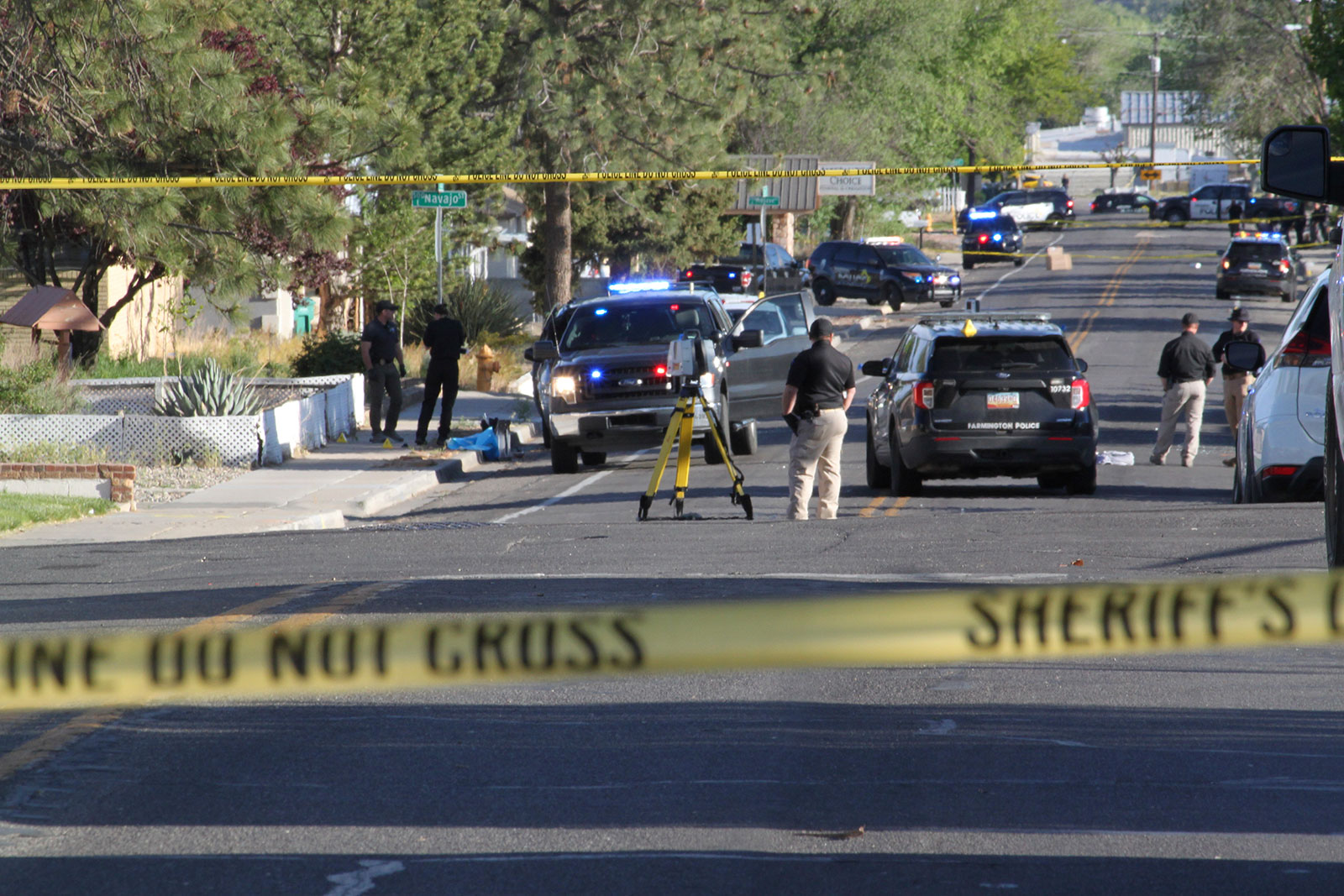 Investigators work along a residential street following a deadly shooting on May 15 in Farmington, New Mexico. 