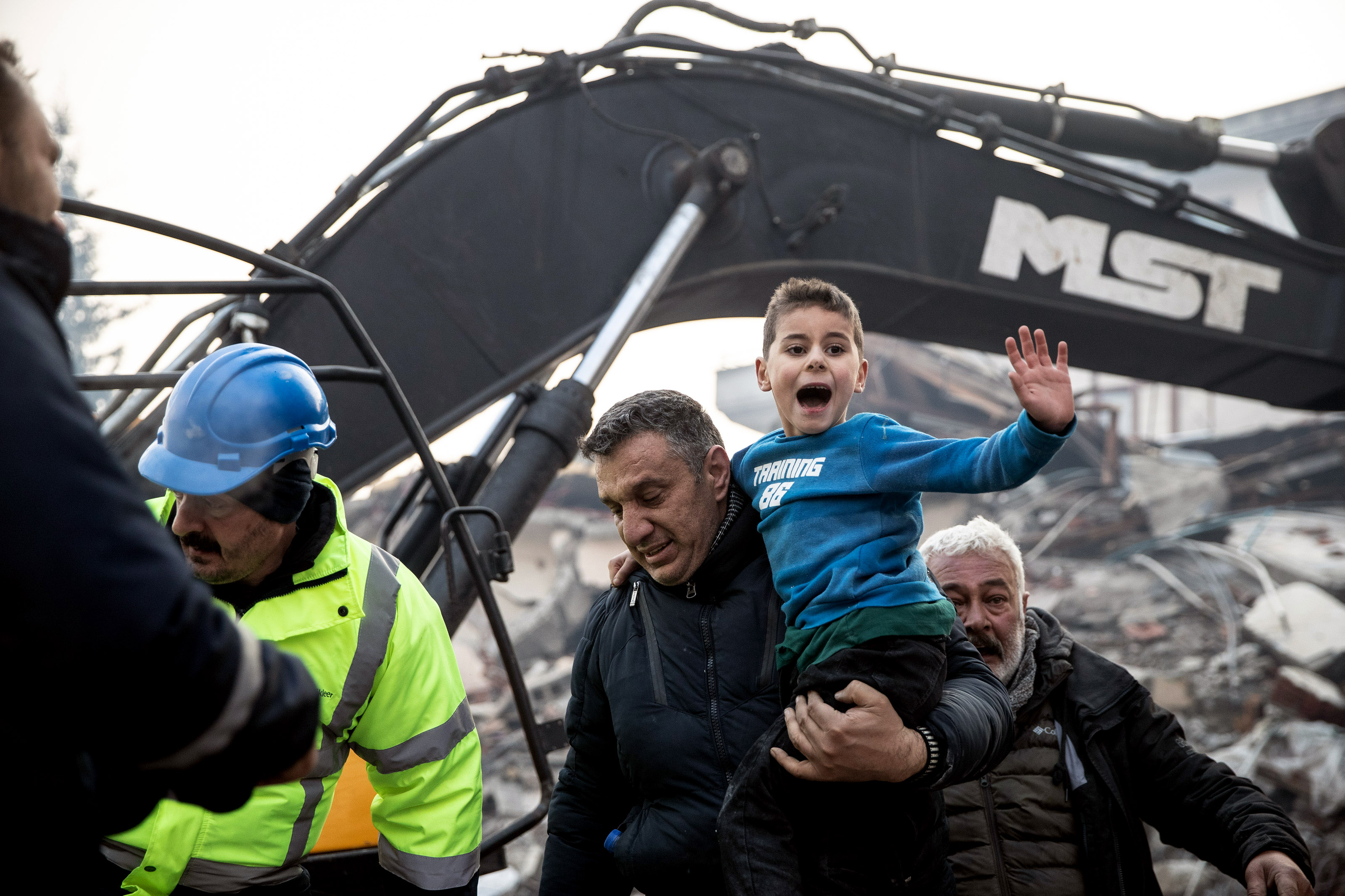 Dramatic photos show the moment an 8-year-old survivor was rescued and reunited with his mother