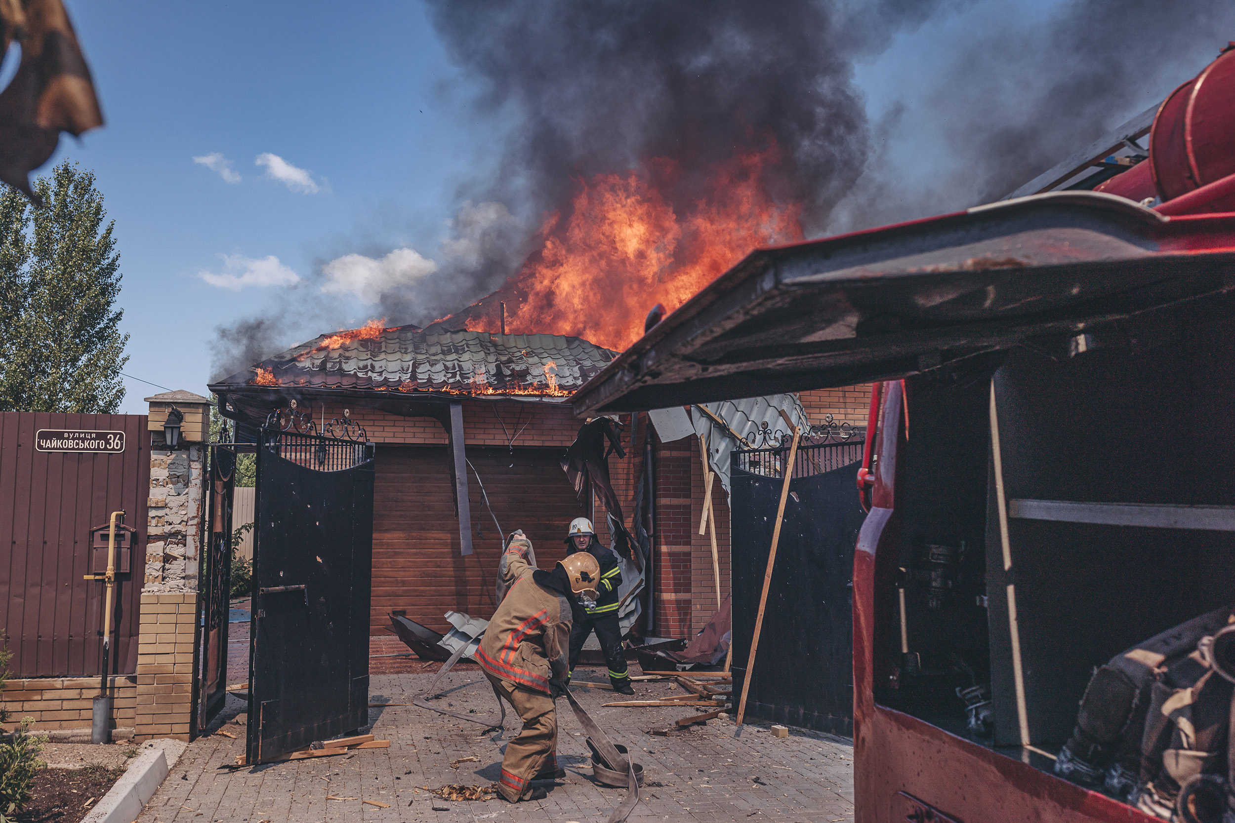 Firefighters try to put out a fire after the Russian shelling of a house in Bakhmut, Ukraine, on July 27.