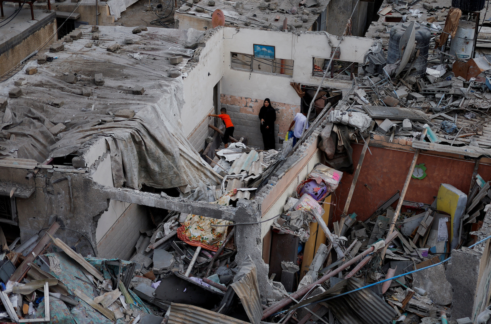 Palestinians check damage at the site of Israeli strikes on houses in Khan Younis on Sunday.