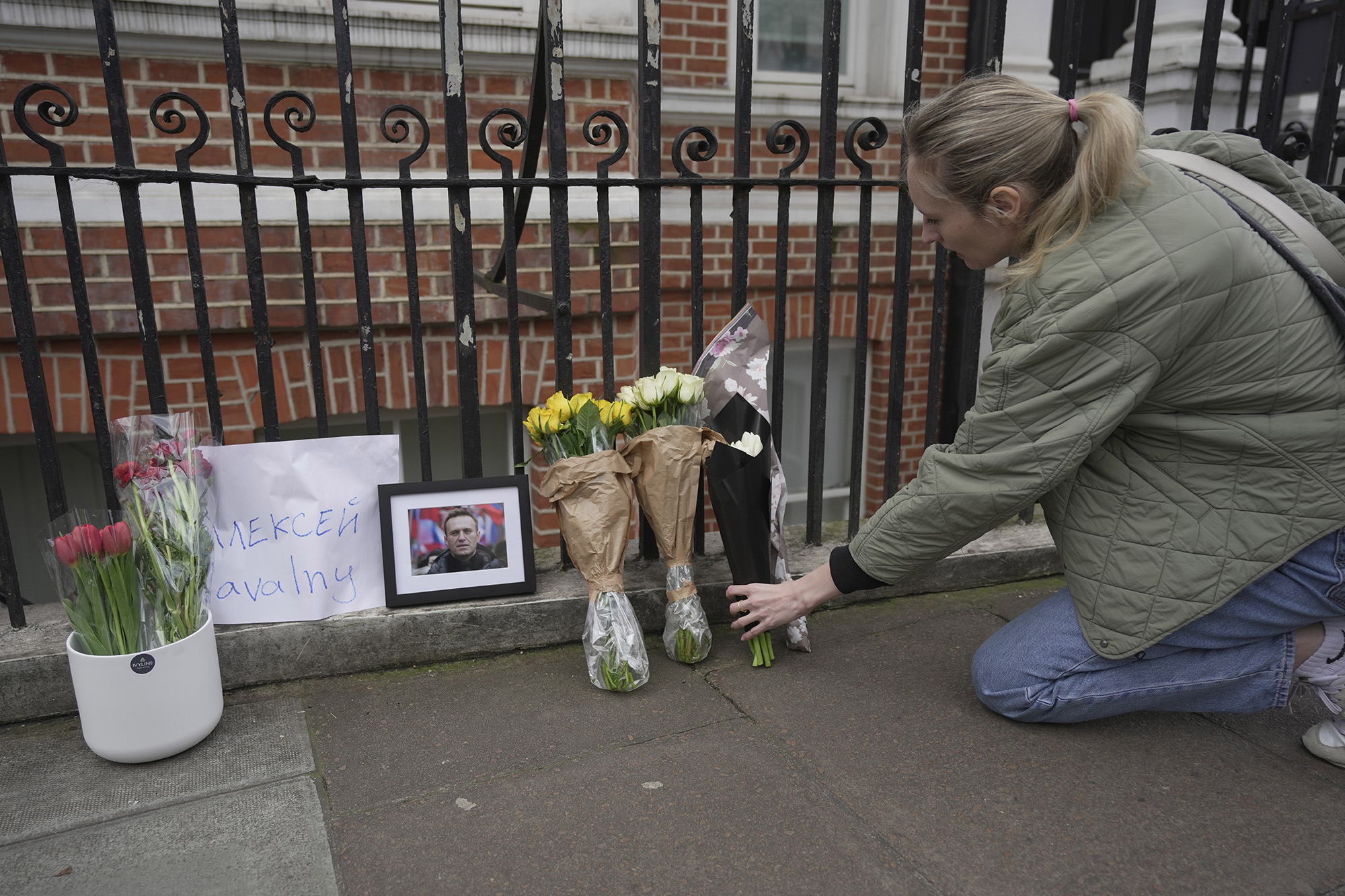 A woman lays floral tribute opposite the Russian Embassy in London, on February 16, in reaction to the news that jailed Russian opposition leader Alexey Navalny has died in a Russian prison.