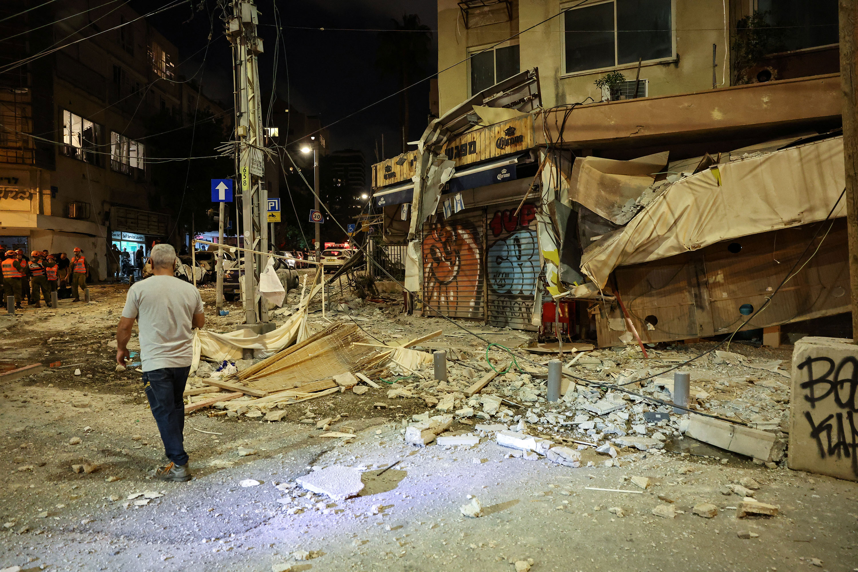 A man walks along a debris-strewn street in Tel Aviv, Israel, after it was hit by a rocket fired from Gaza on October 7. 