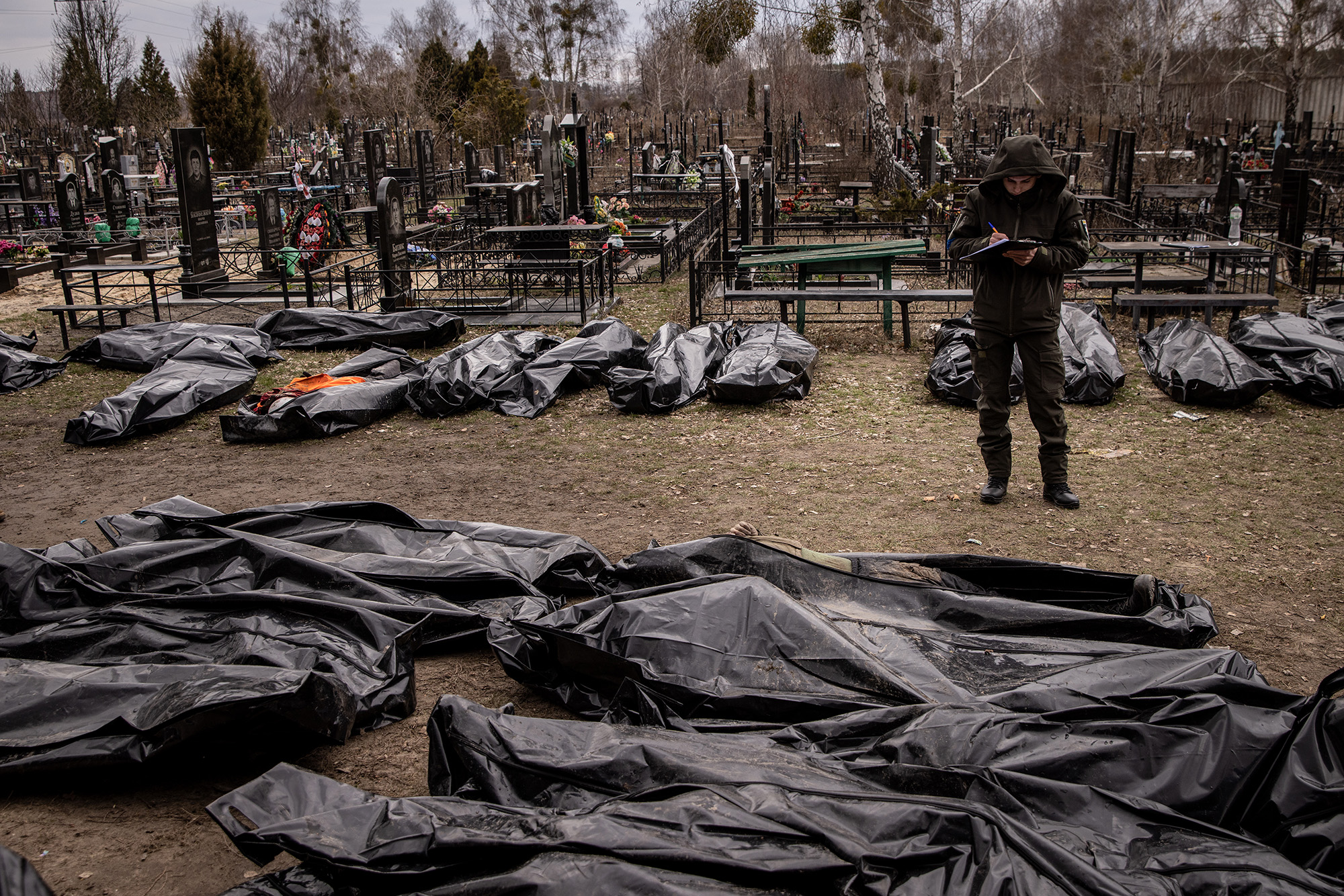 En man arbetar med att katalogisera några kroppar av civila dödade i och runt Bucha innan de transporteras till ett bårhus den 6 april.