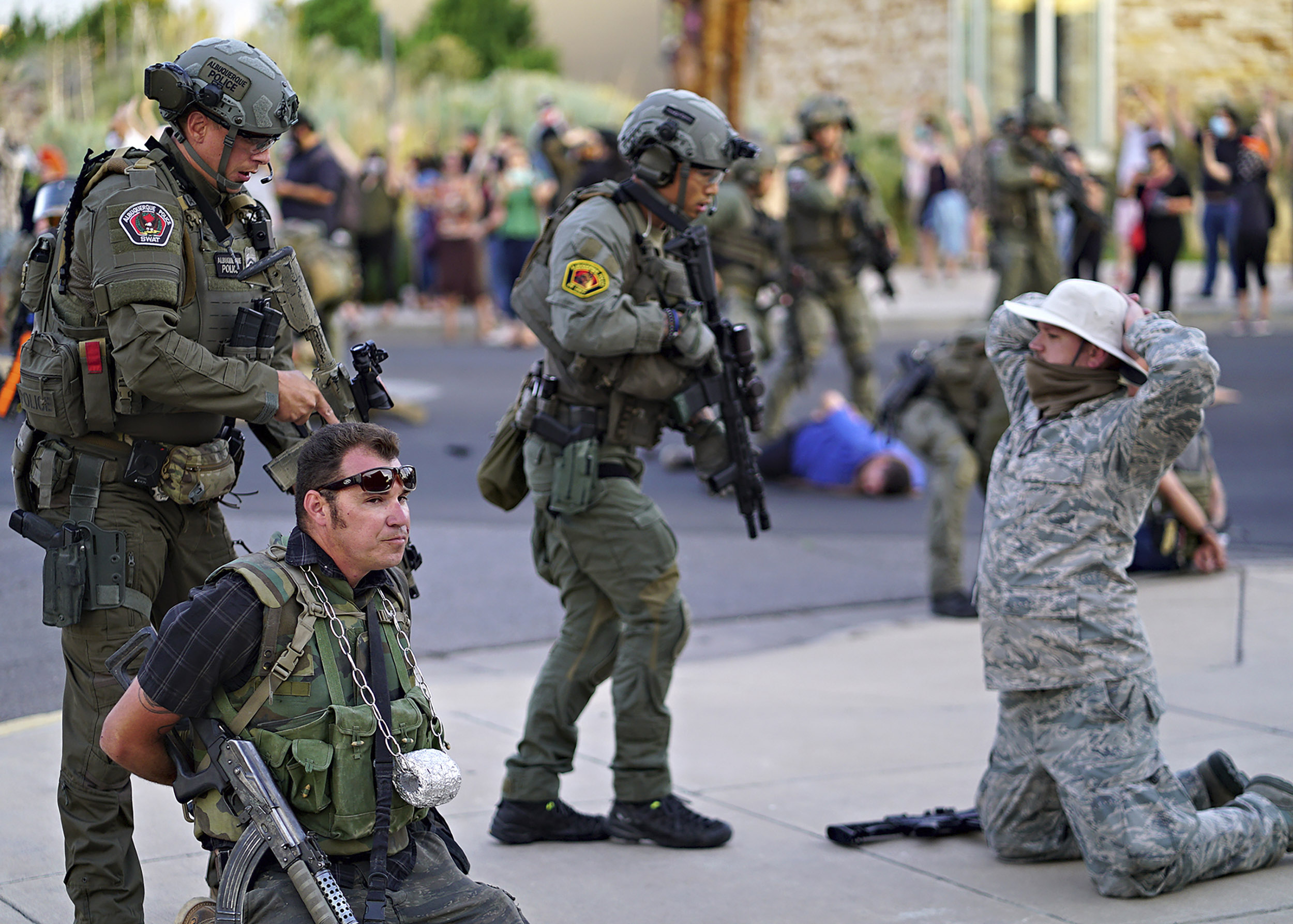 Albuquerque police detain members of the New Mexico Civil Guard, an armed civilian group, following the shooting of a man during a protest over a statue of Spanish conquerer Juan de Oñate on Monday, June 15, in Albuquerque, New Mexico. 