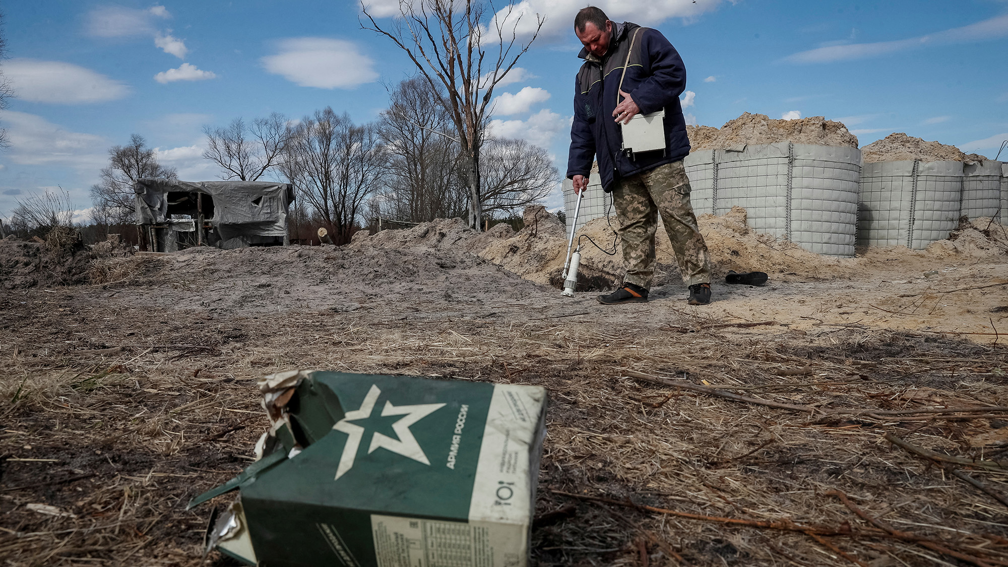 A dosimetrist measures the level of radiation around trenches dug by the Russian military in an area with high levels of radiation called the Red Forest near the Chernobyl Nuclear Power Plant, in Chernobyl, Ukraine on April 7.