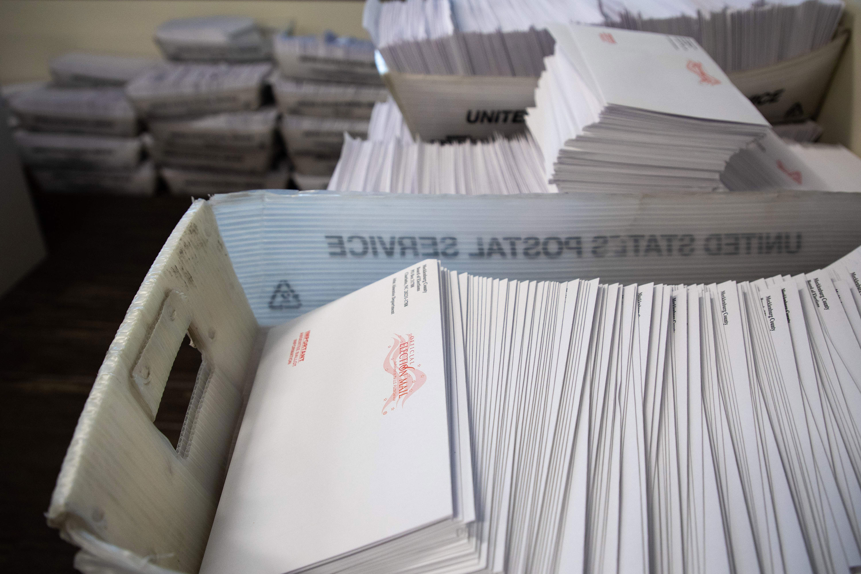 Large boxes of envelopes are seen as absentee ballot election workers stuff ballot applications at the Mecklenburg County Board of Elections office in Charlotte, North Carolina, on September 4.