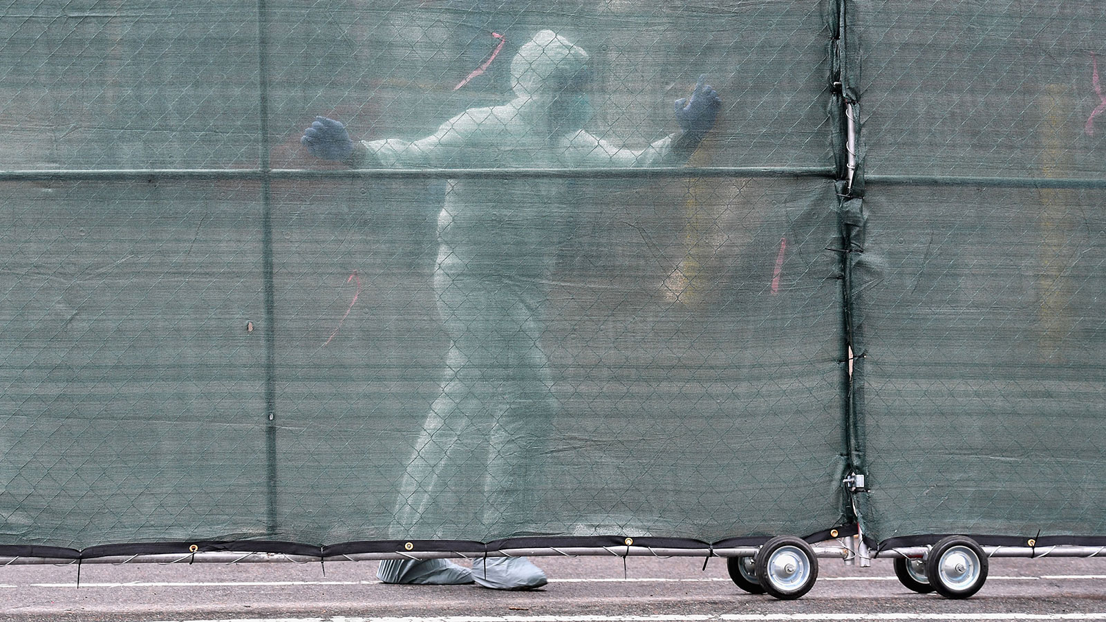 Medical personnel moves a fence in front of refrigerated trucks serving as make shift morgues at Brooklyn Hospital Center in New York City on April 9. 