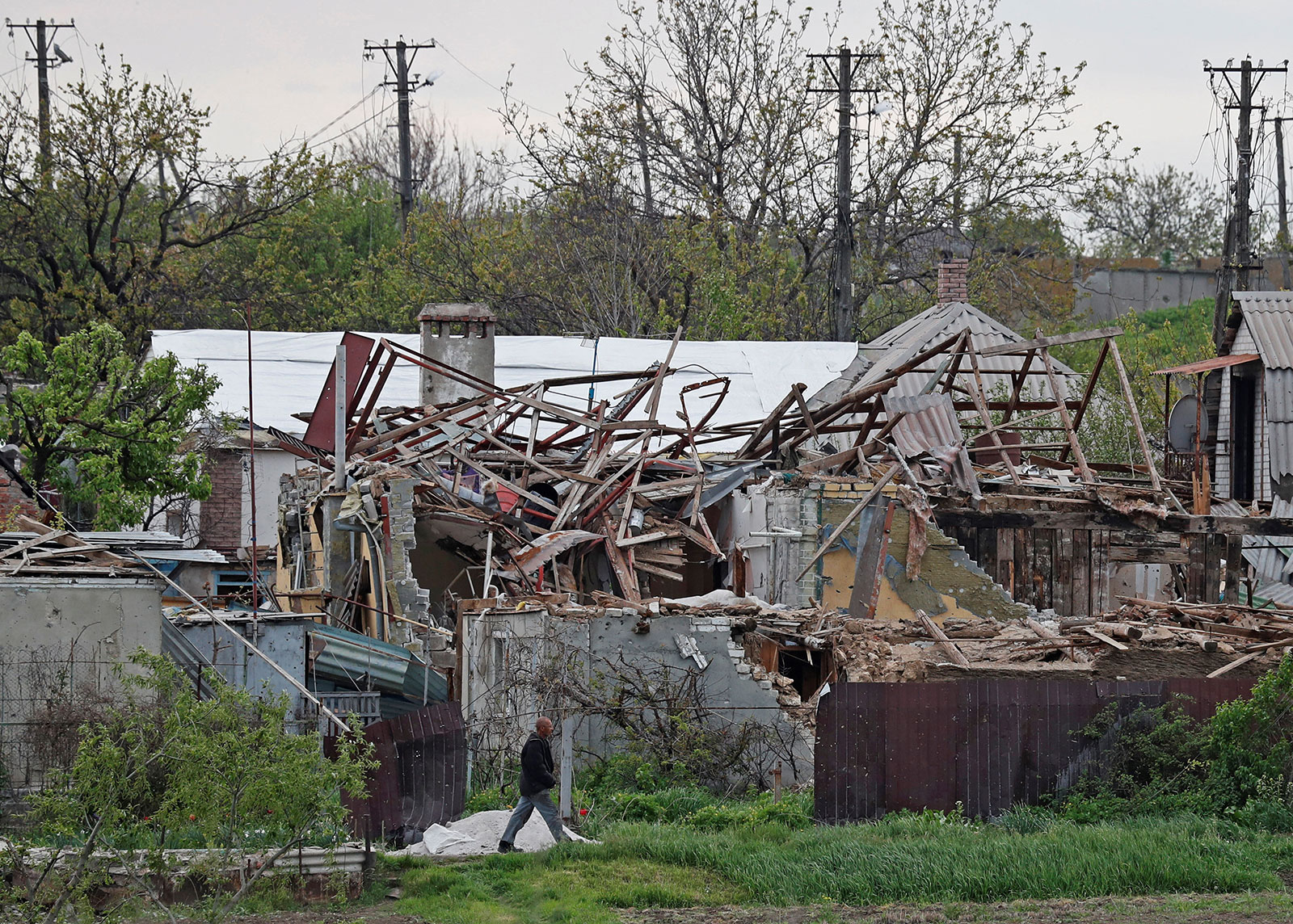 A local resident walks past houses destroyed in Mariupol, Ukraine, on May 5. 